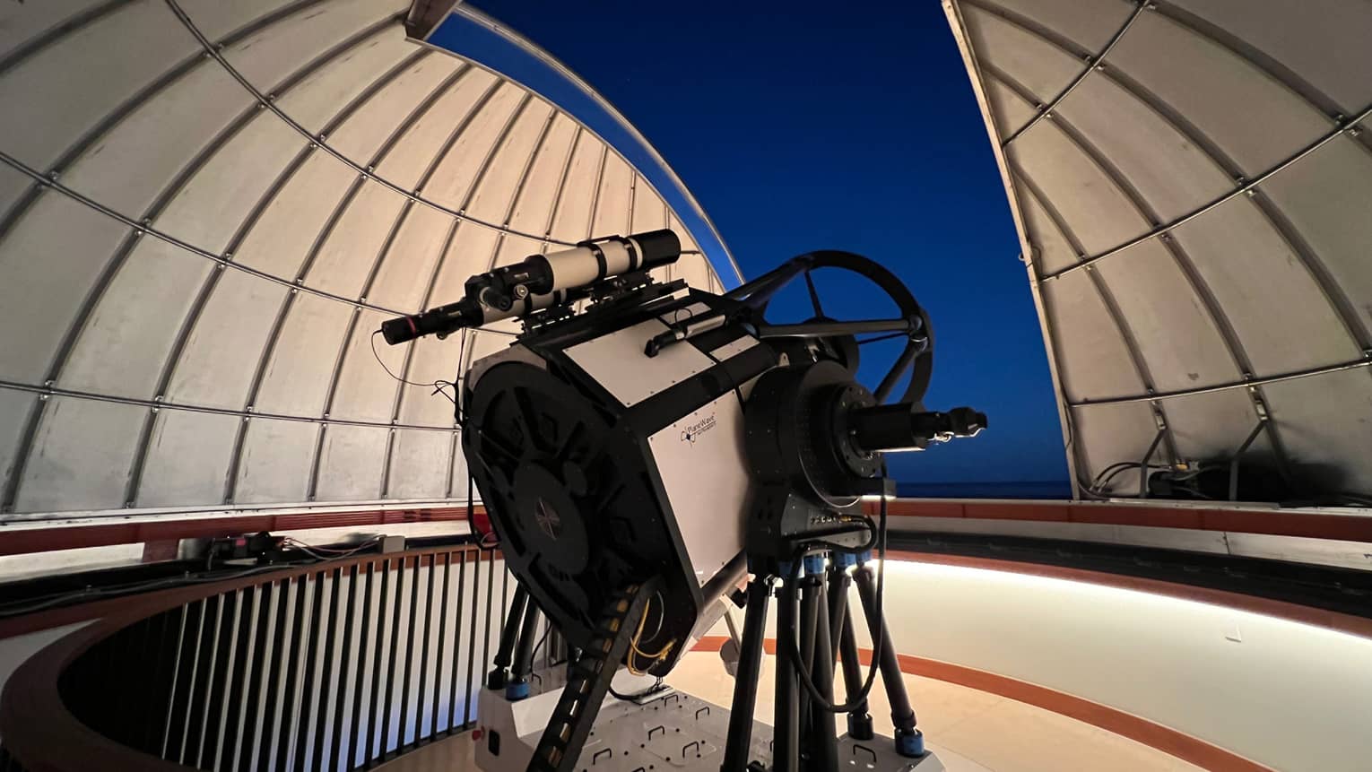 Large telescope from the Lanai Observatory peering out of a dome into the night sky