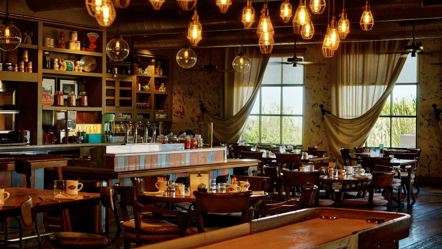 Proof restaurant with shuffleboard table and hanging lights, at Four Seasons Resort Scottsdale