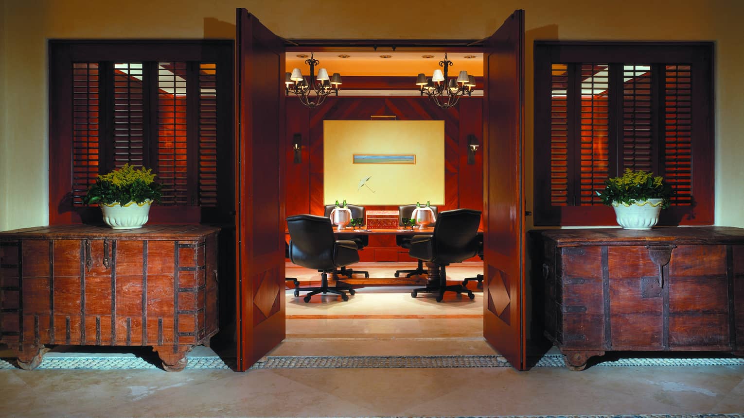 Rustic trunk cabinets flank open doors to Tau meeting room, table