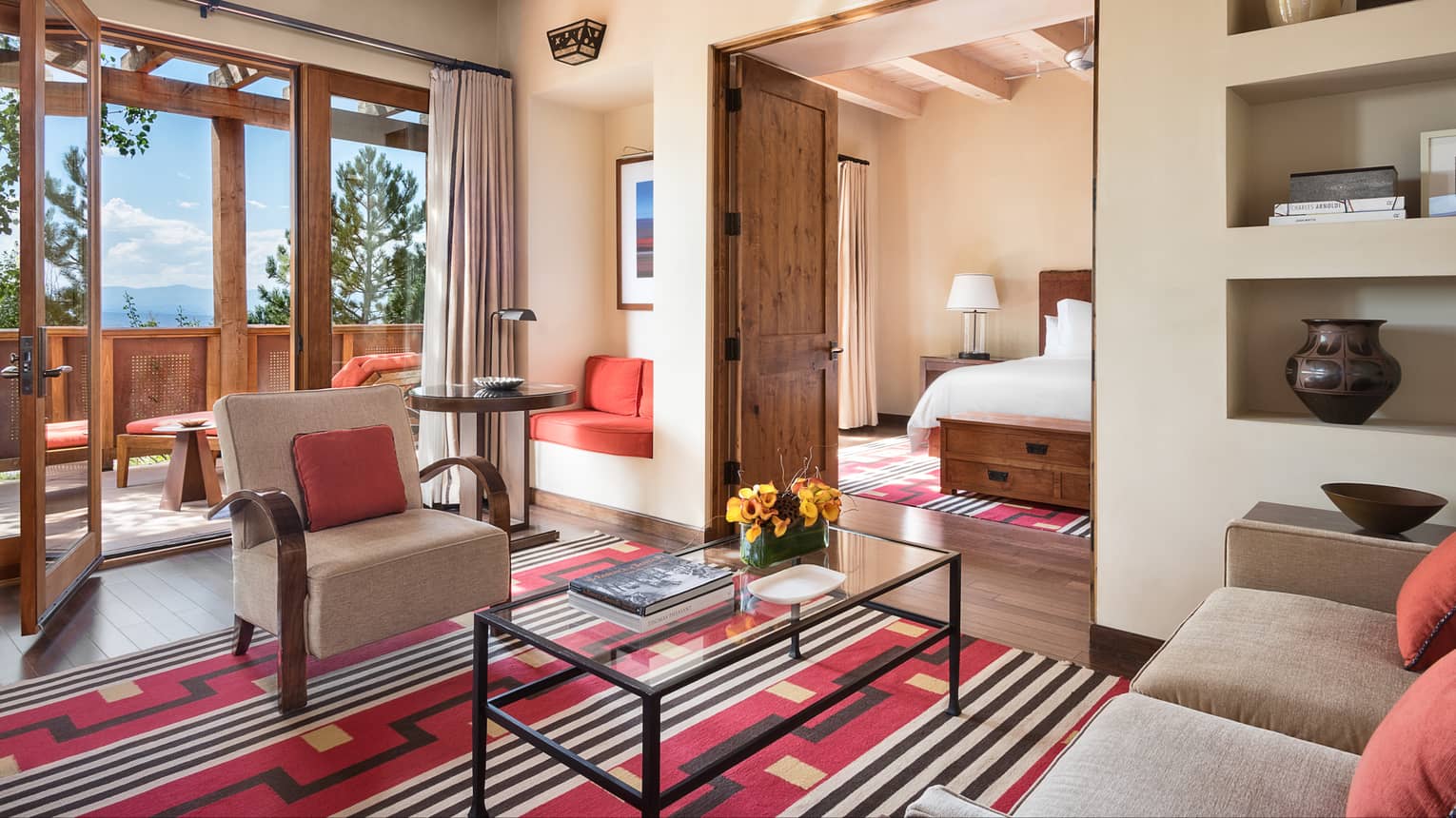 Sunset Suite living room, Southwestern-style rug, wood doors to balcony, bedroom