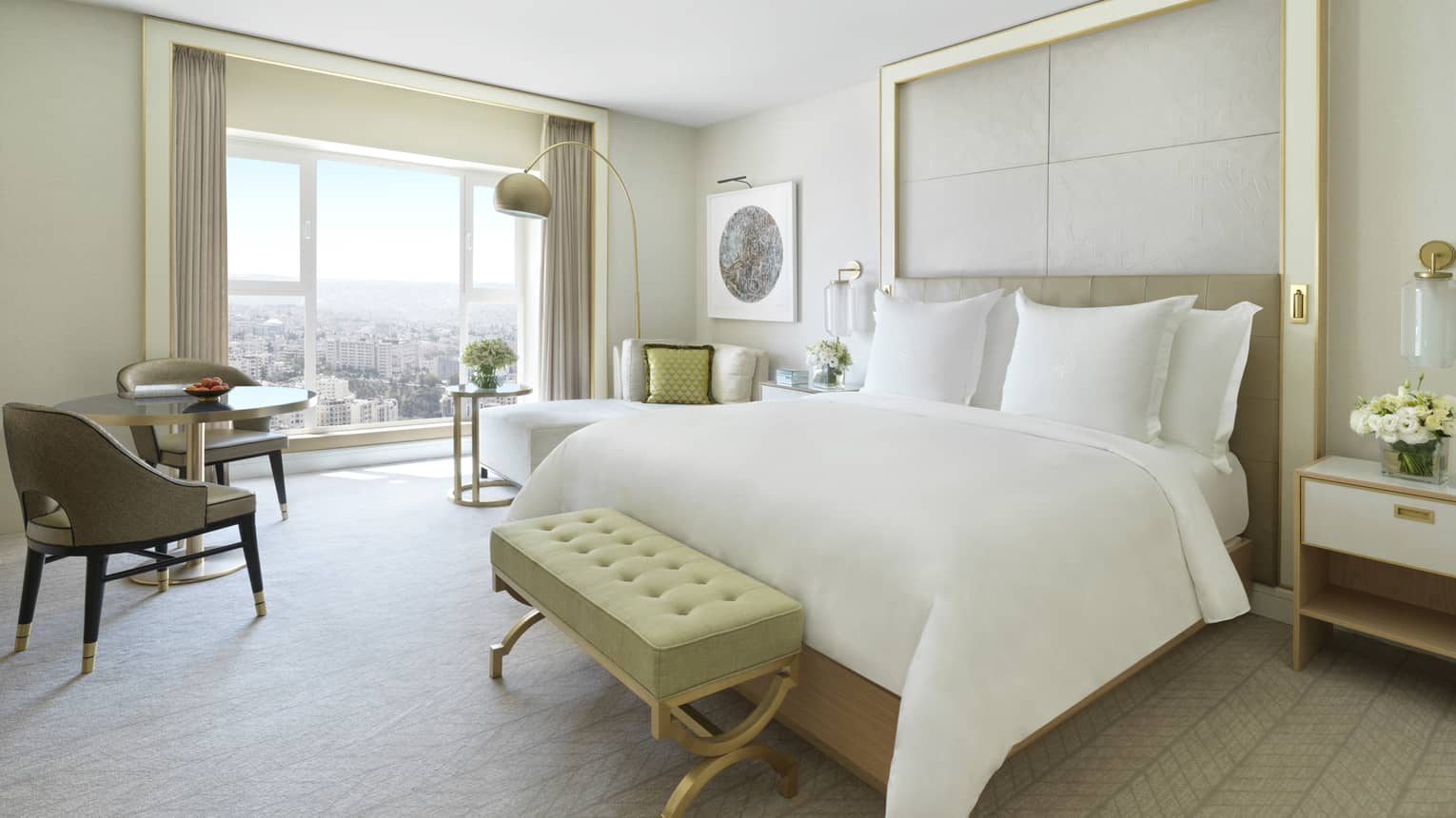 A spacious suite with a large bed in the centre of the room. Opens to a floor-to-ceiling window overlooking Amman.