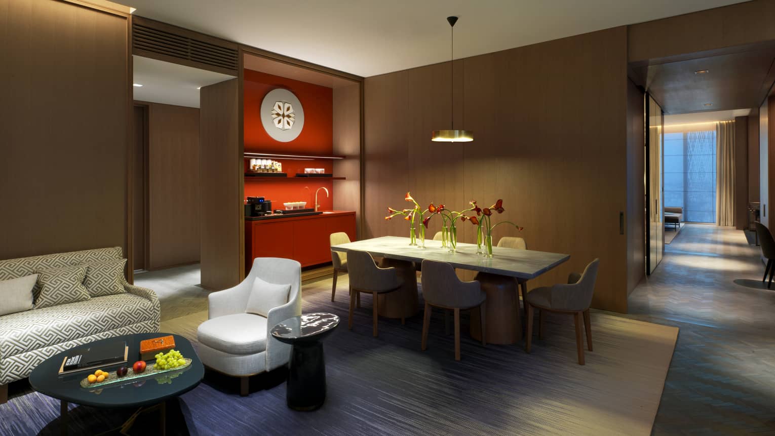 Ambassador Suite private dining table in front of wood panel bar, red wet bar, modern sofa, chair