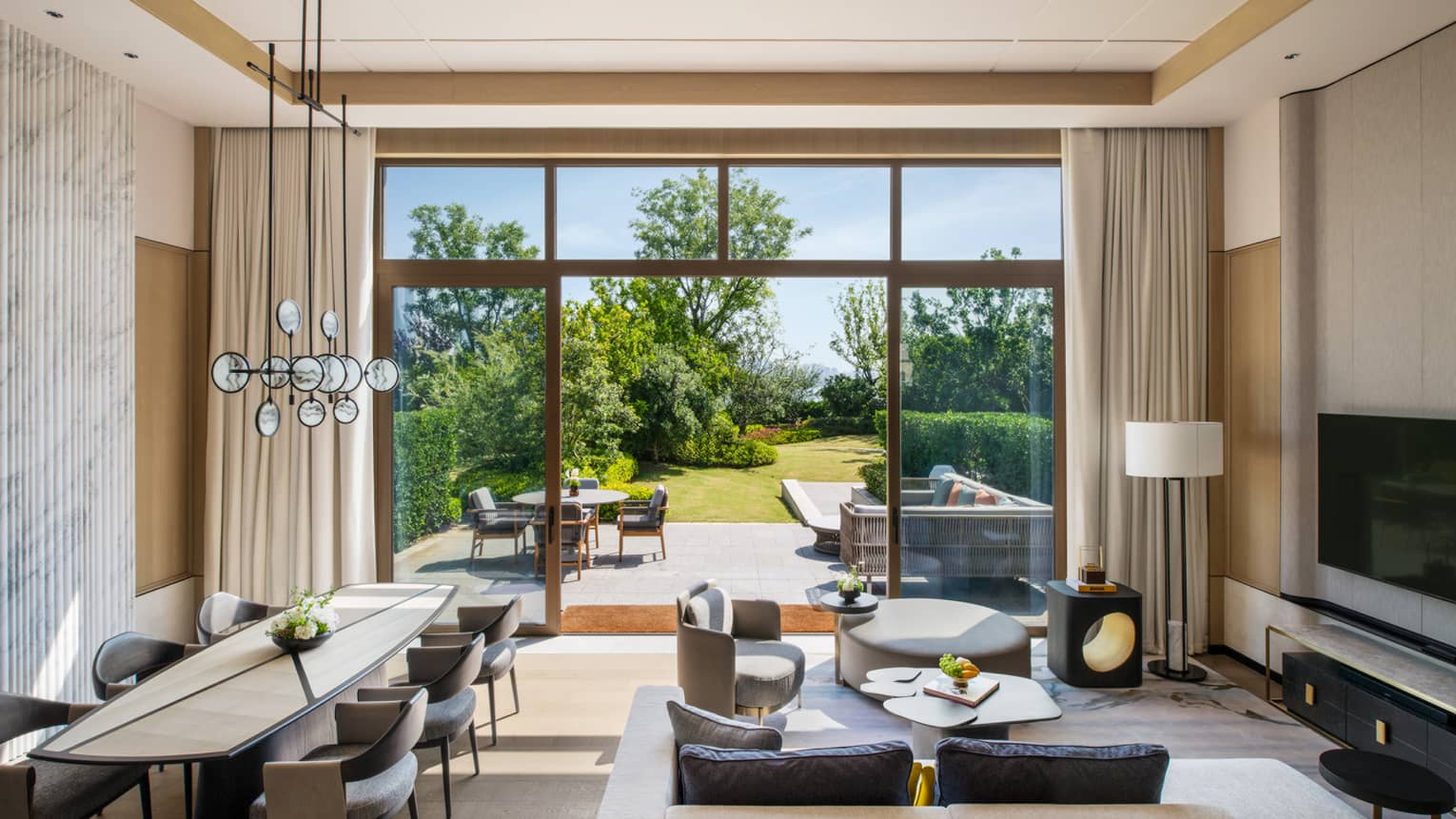 Two-Bedroom Garden Villa at Four Seasons Hotel Suzhou, with contemporary living room and dining table for six, and walk-out terrace