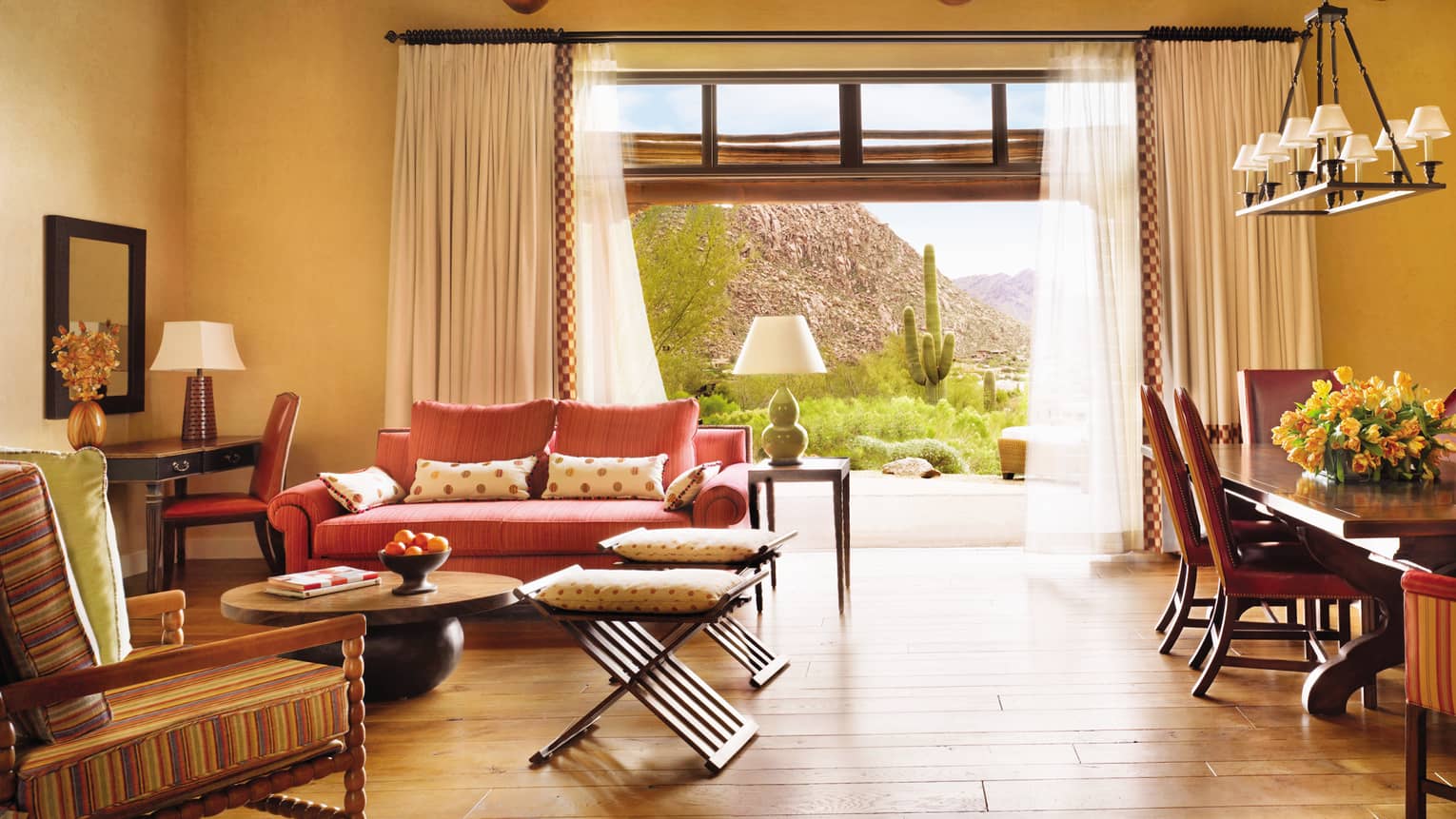 Indoor-outdoor living room with sofas in front of large open wall, curtains to patio