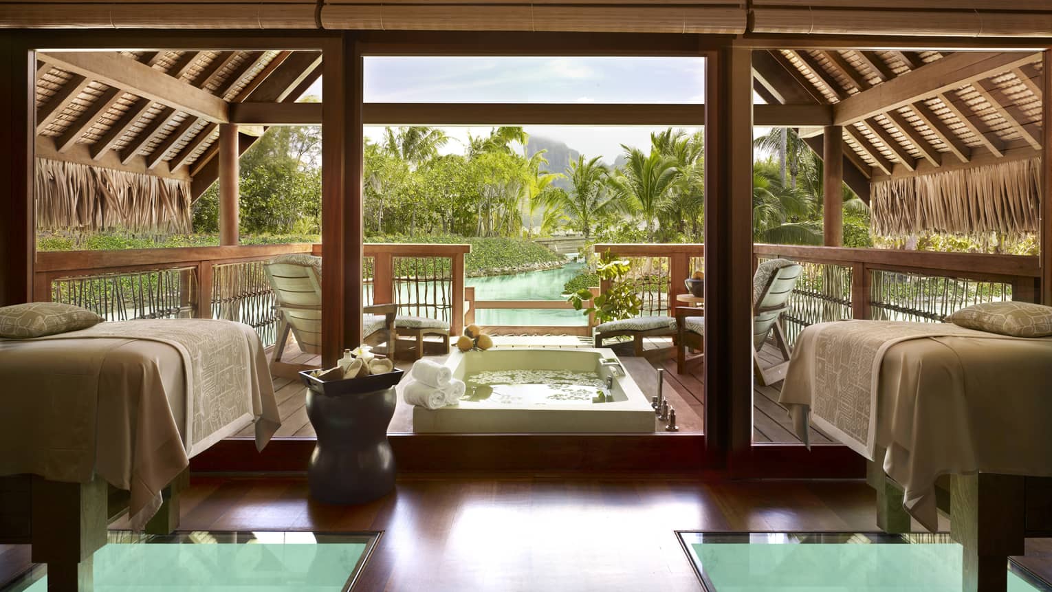 Outdoor spa pavilion with couples massage beds by plunge bath on patio