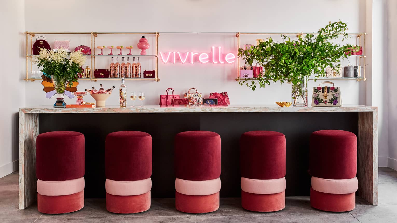 A small store with red stools and a counter space, with neon lights and plants behind it.