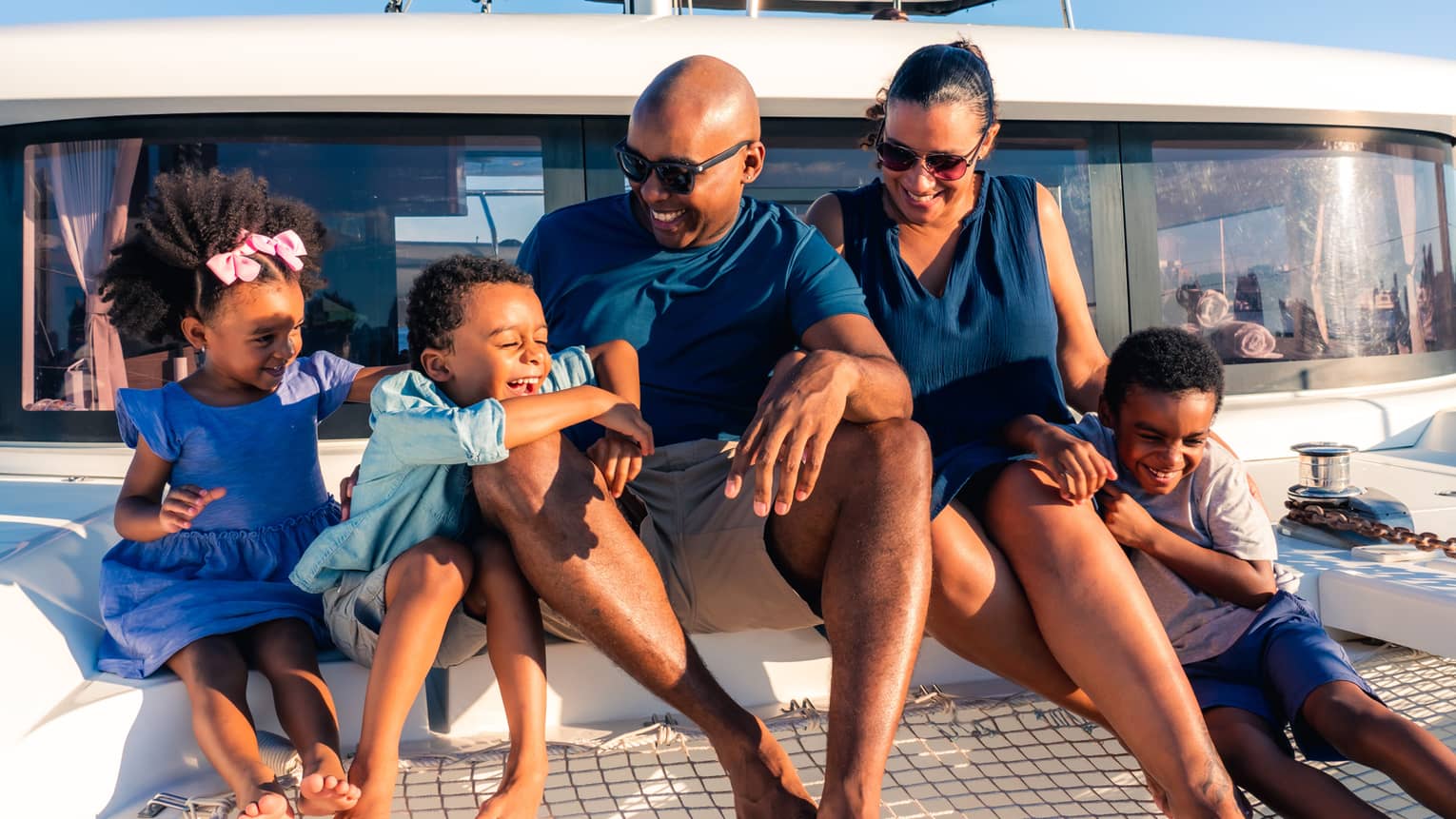 A family sits on overwater net of luxury catamaran