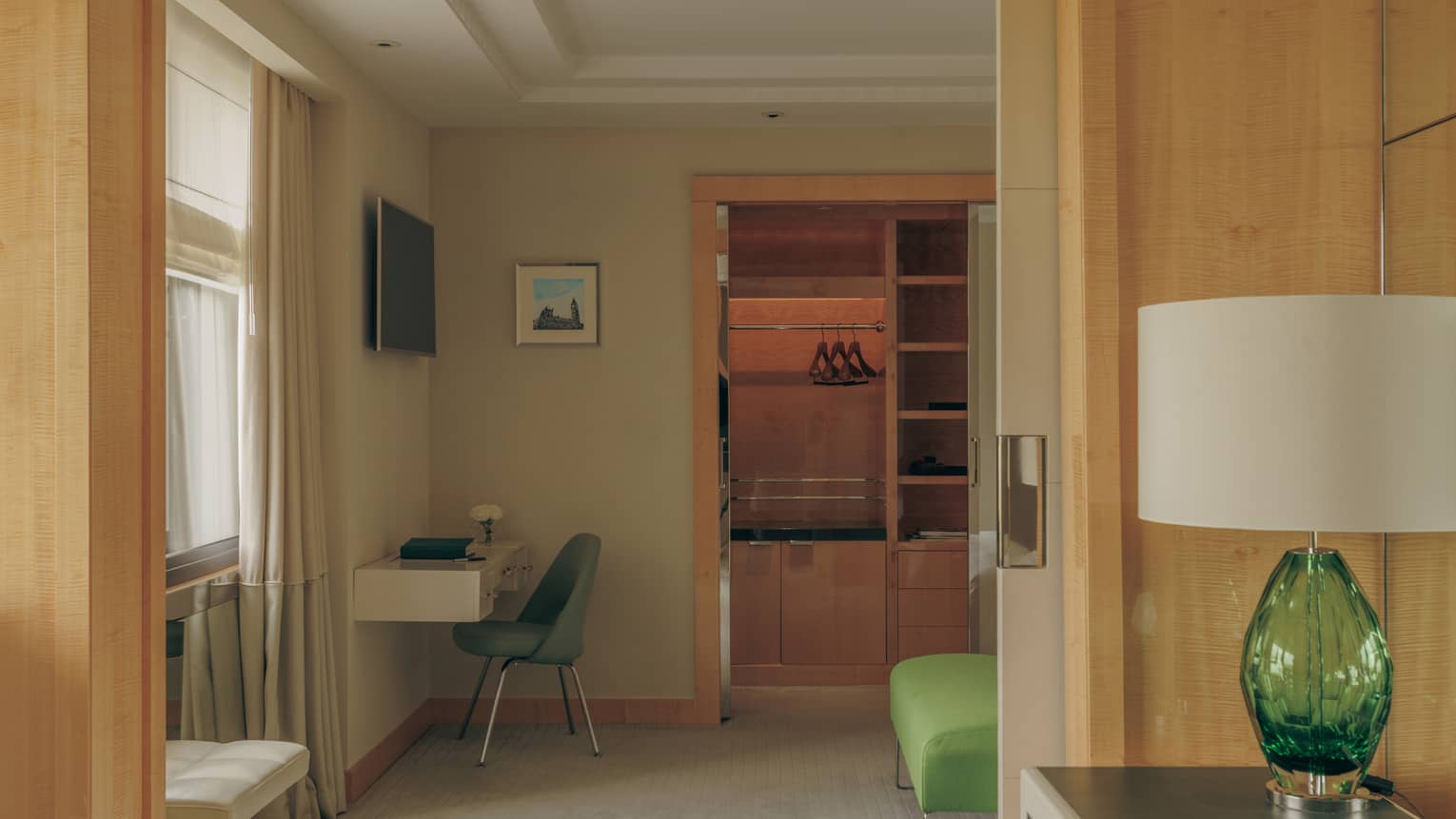 Interior of a luxury hotel suite featuring a desk and sofa