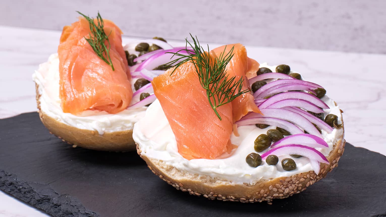 Bagel topped with cream cheese and slices of onions