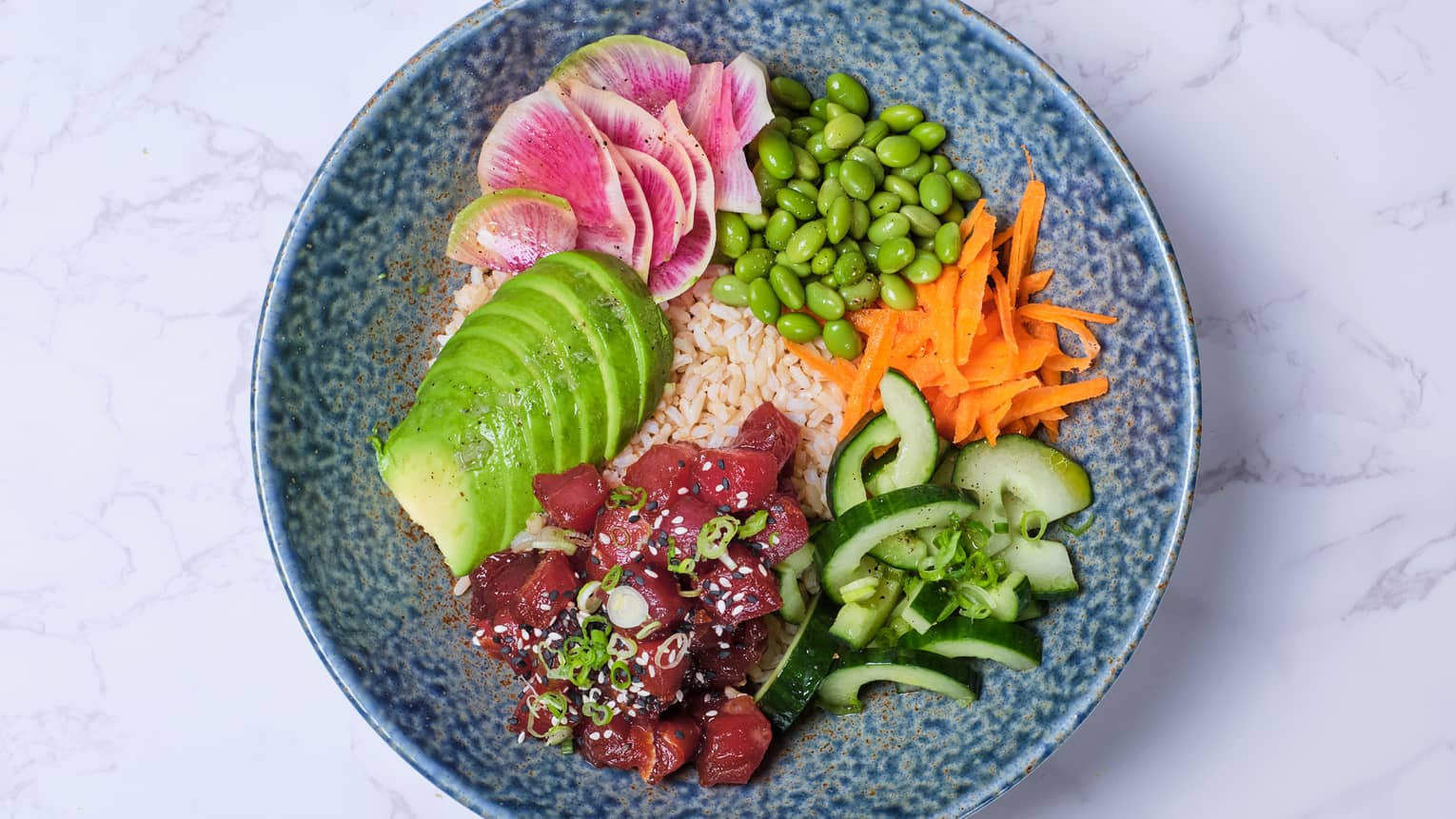 A tuna poke bowl with carrots, avocado, cucumber and edamame