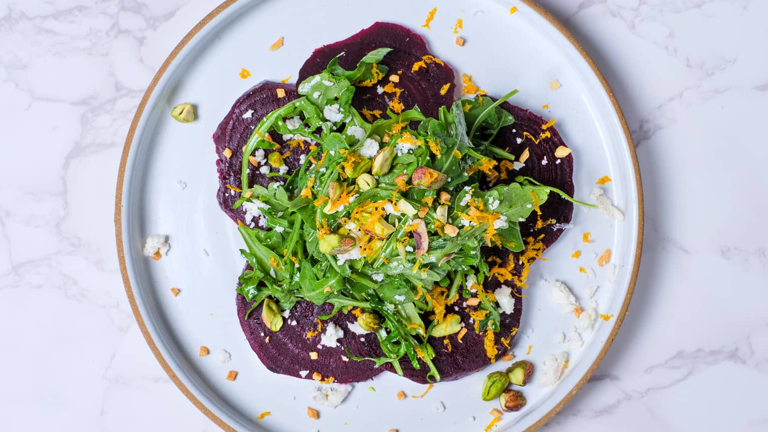A culinary dish on a marble table topped with lettuce