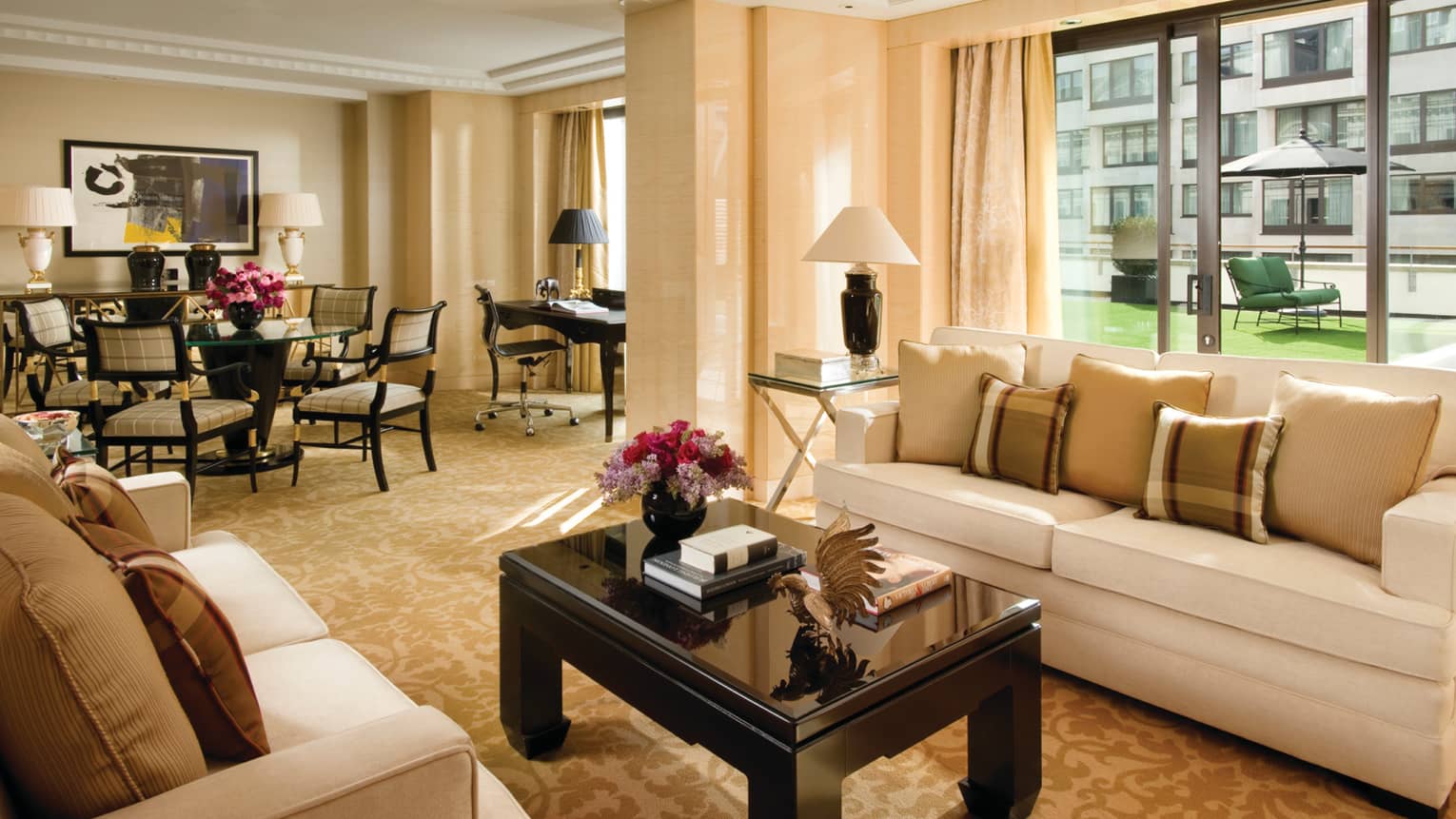 Terrace Suite living room, books, flowers on coffee table, dining room, large windows, patio