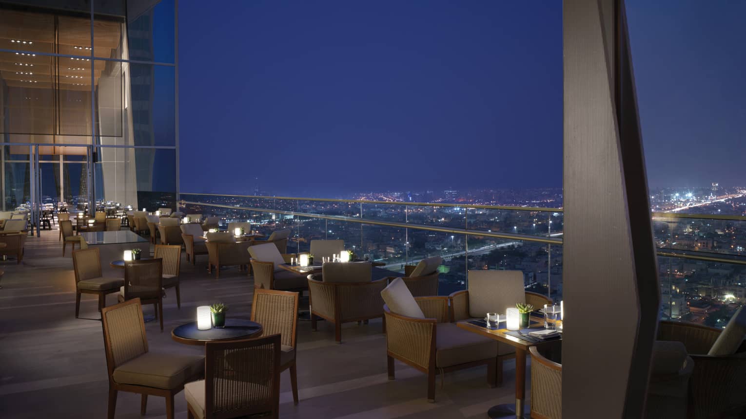 Several tables set up on the outdoor terrace overlooking Kuwait