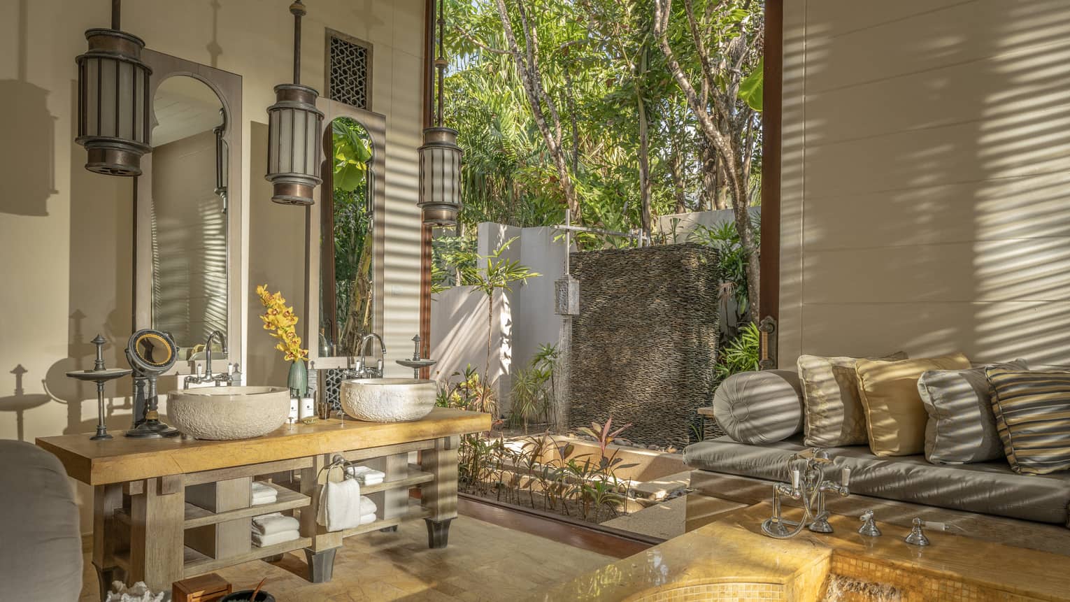 Large bathroom with natural materials, sofa and outdoor shower