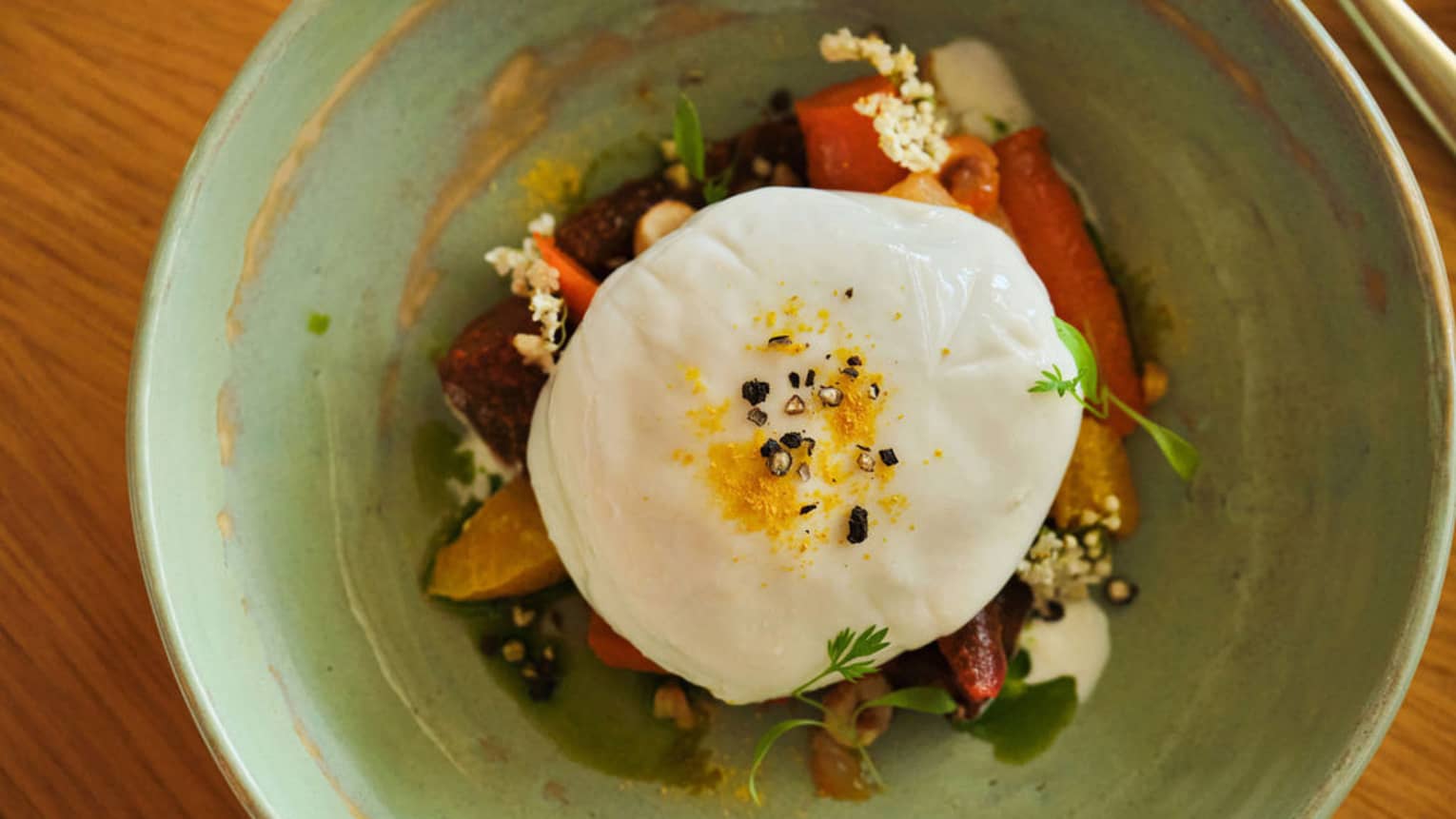 Burrata paired with seasonal produce, bright citrus and delicate herbs