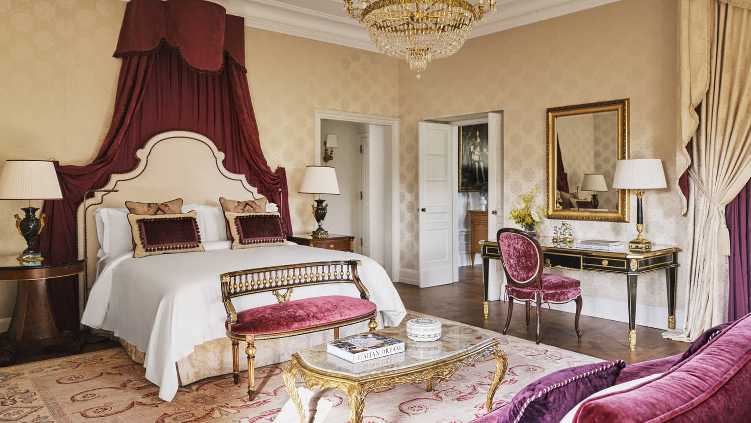 Presidential Suite bedroom with king bed, ruby-red canopy detailing, and matching velvet sofa and chair, at Four Seasons Hotel Florence