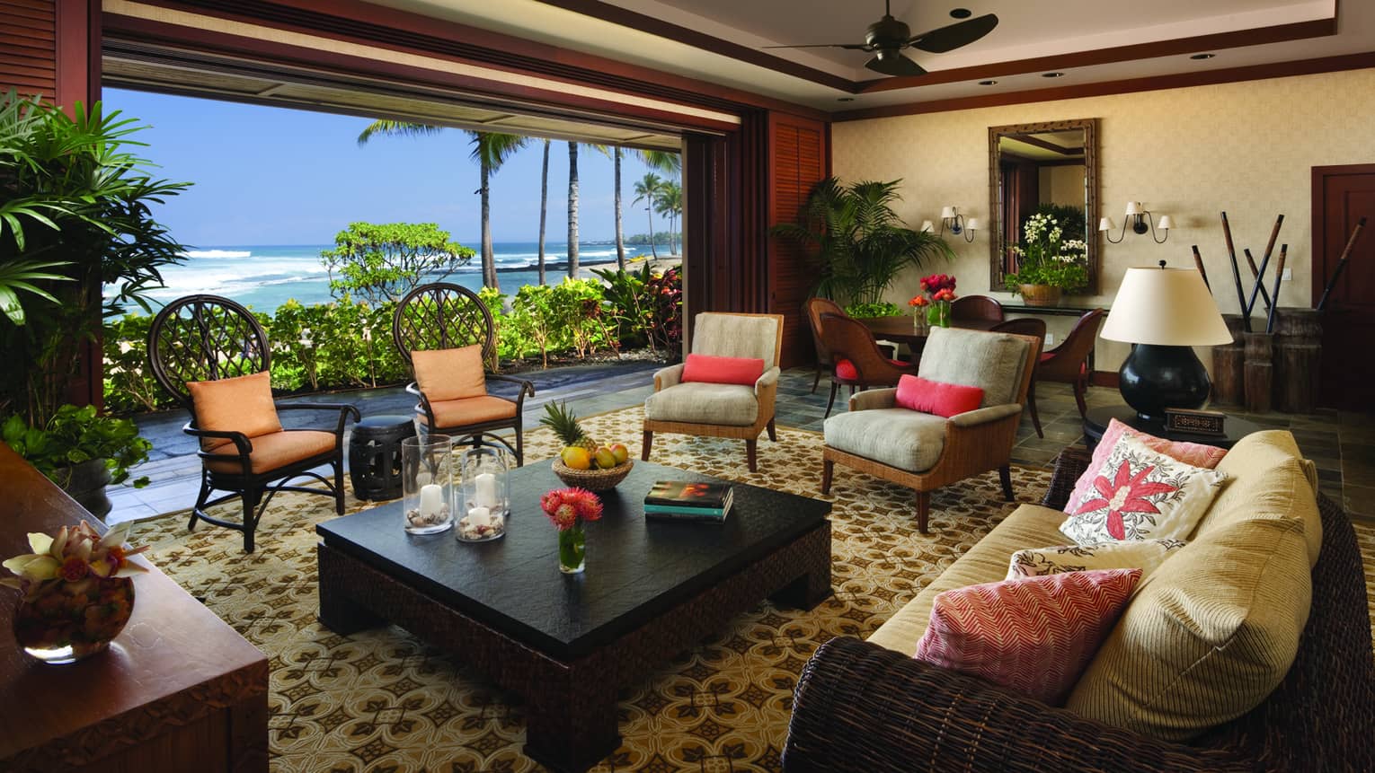 Ho'onanea Villa living room wicker sofa, cushioned chairs by open wall, ocean view