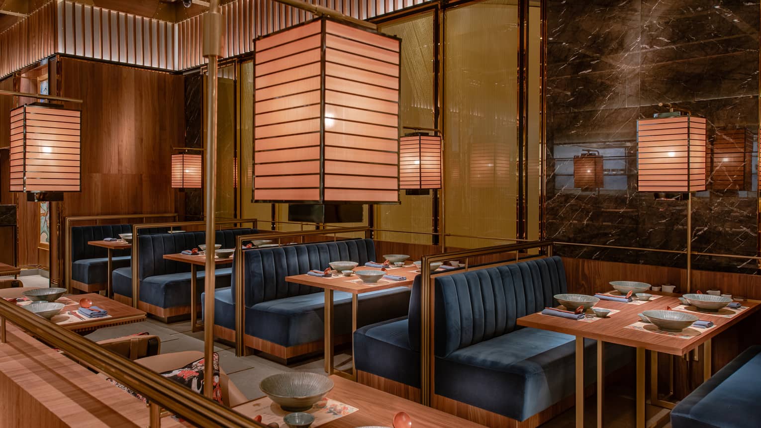 Plush dining booths beneath golden lighting at Four Seasons’ Ohte restaurant in Macao.