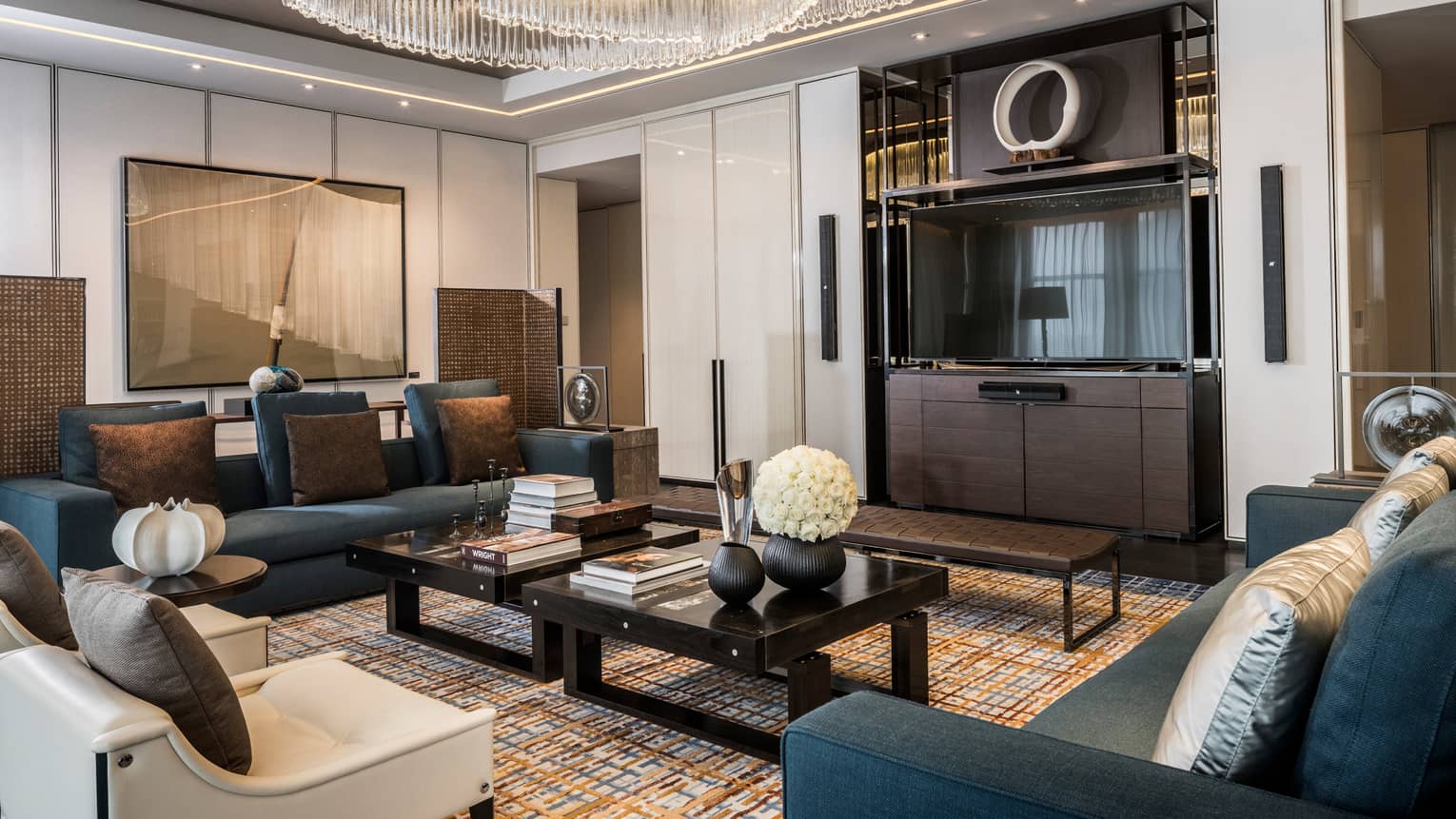 Presidential Three-bedroom Suite living room sofas, armchairs around two coffee tables, TV under chandelier