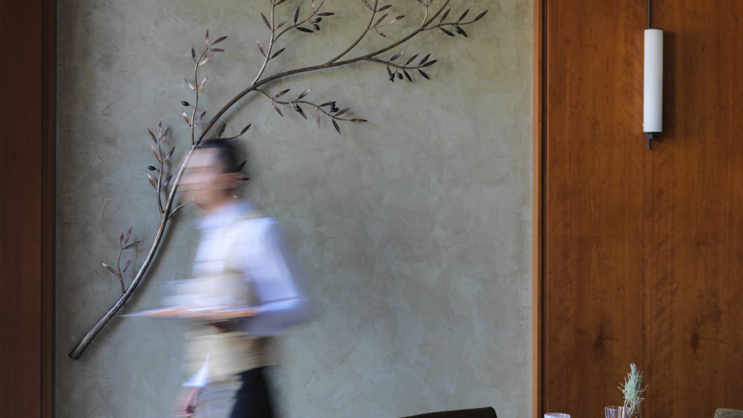 Waiter walking quickly past restaurant dining table