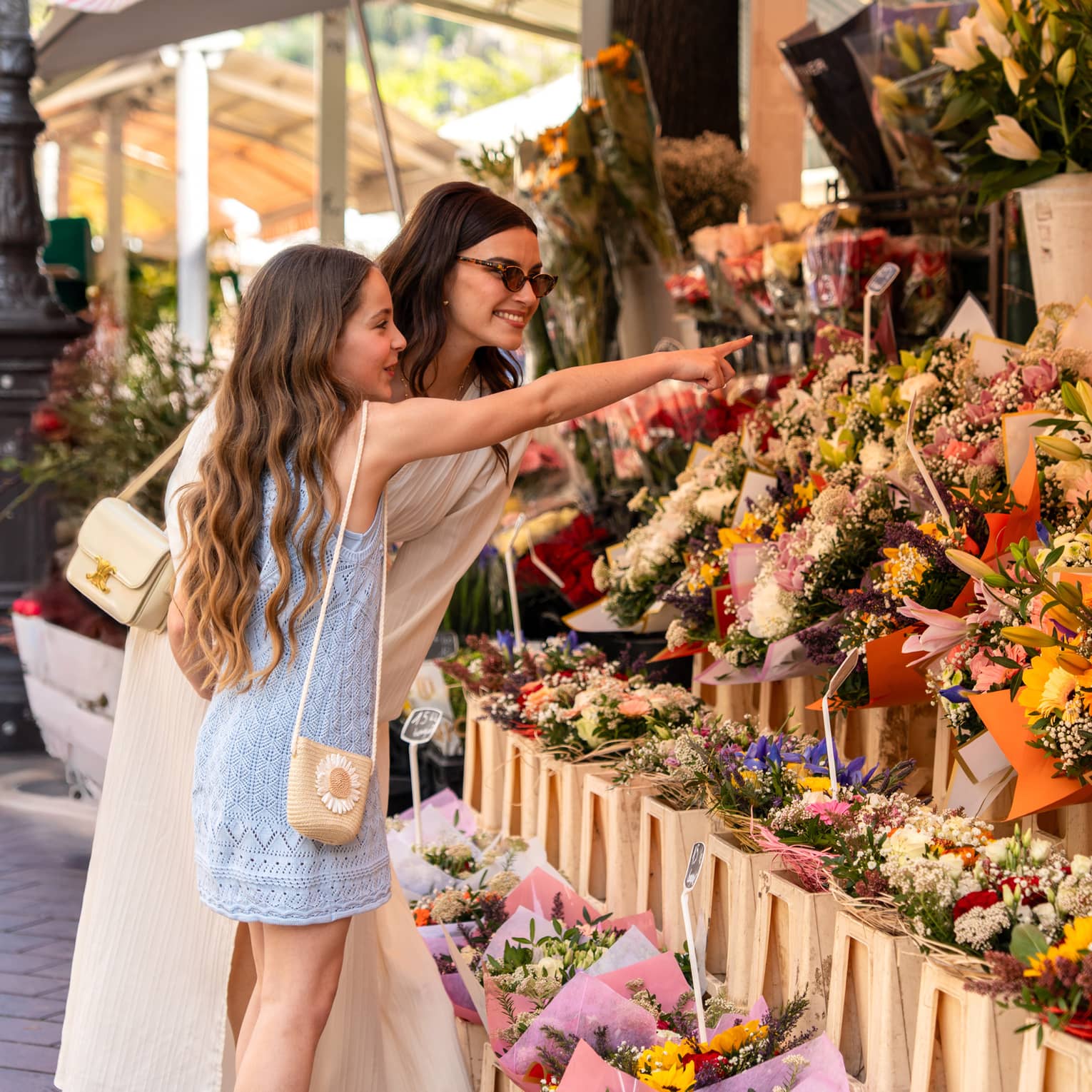 Two guests standing near a display of flowers at an outdoor shop