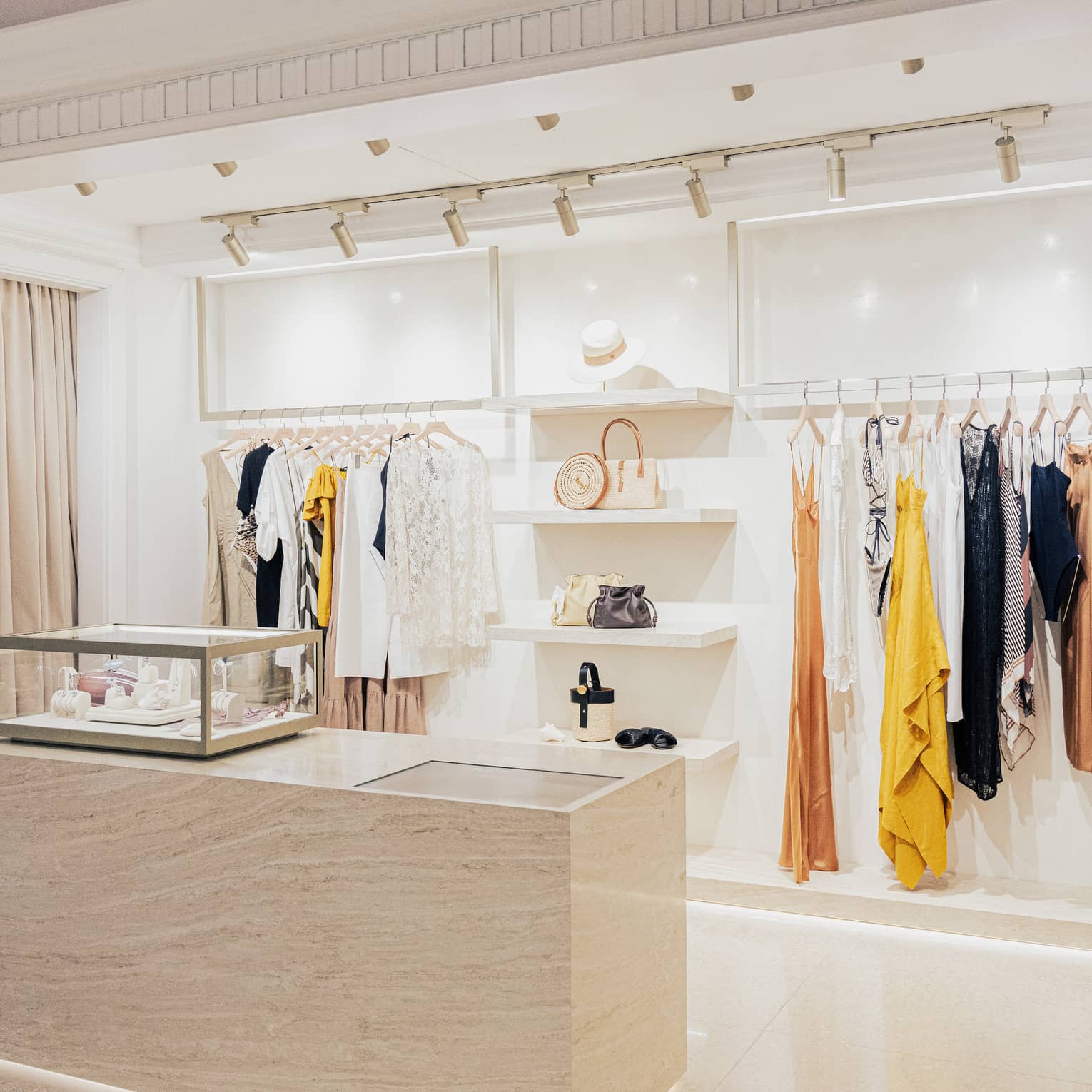 Contemporary boutique with white shelving and stylish clothes