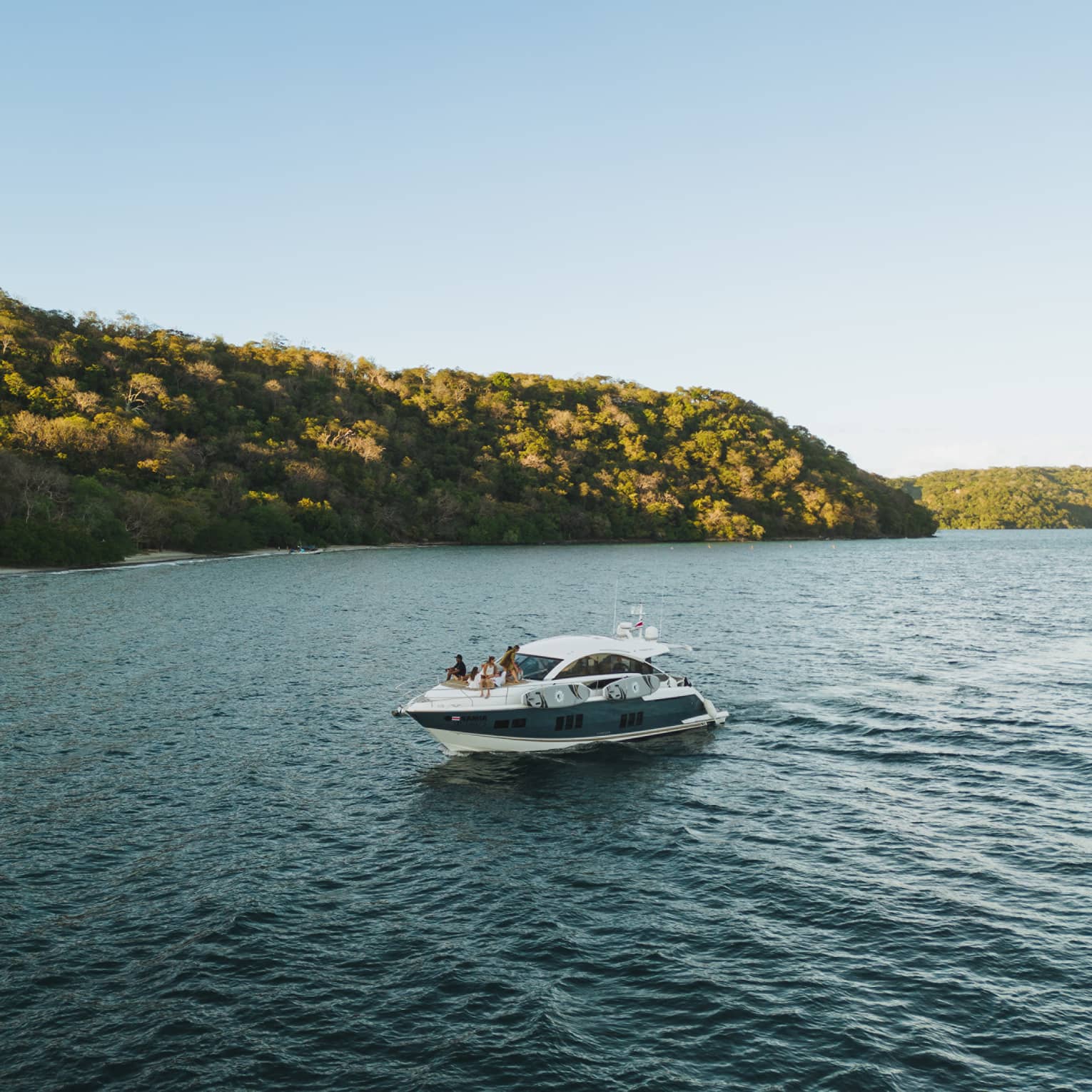 Power boat on water near green hills