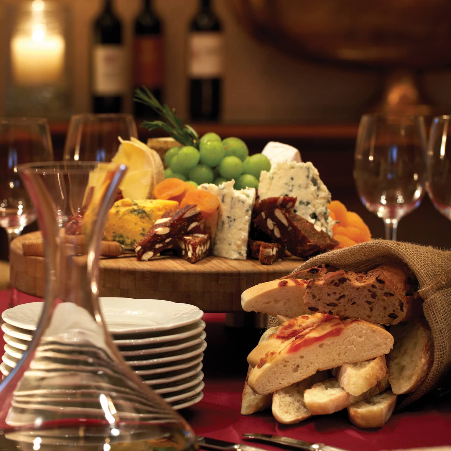 Cheese and fruit platter, wine glasses in dimly lit fine dining room