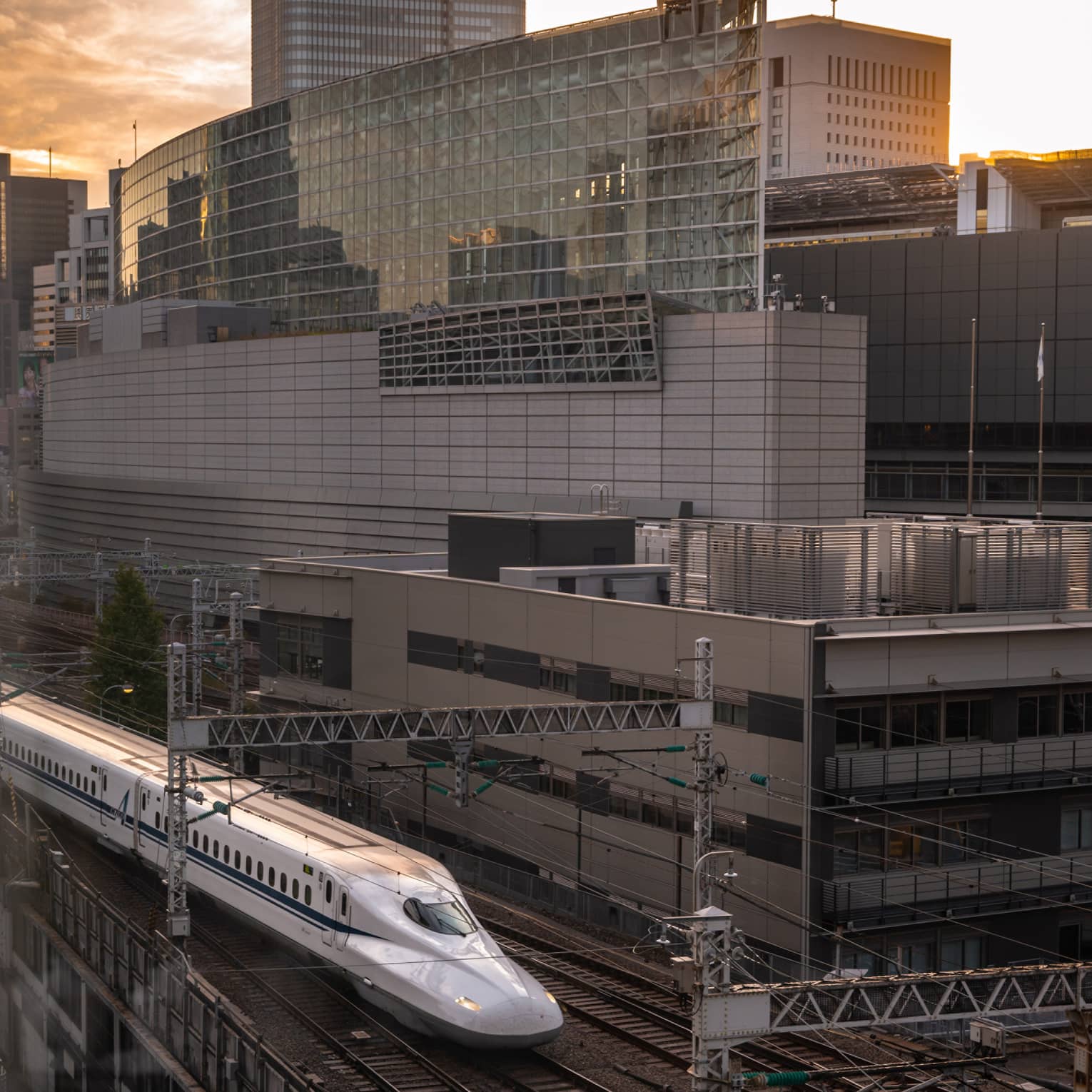 Shinkansen bullet train arrives at the station at sunset