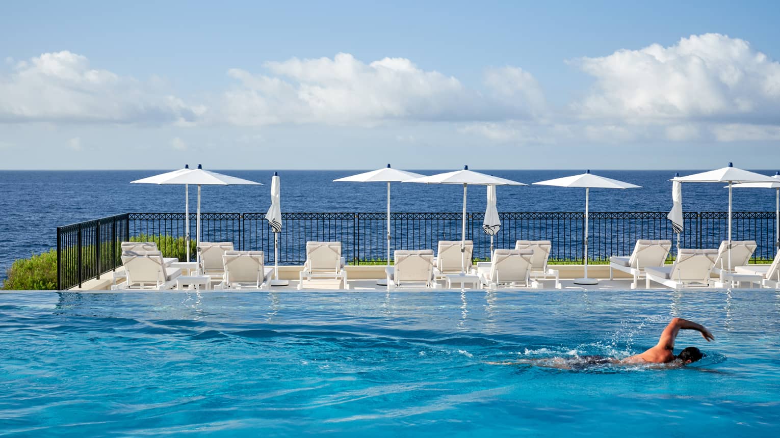 Man swimming in infinity pool