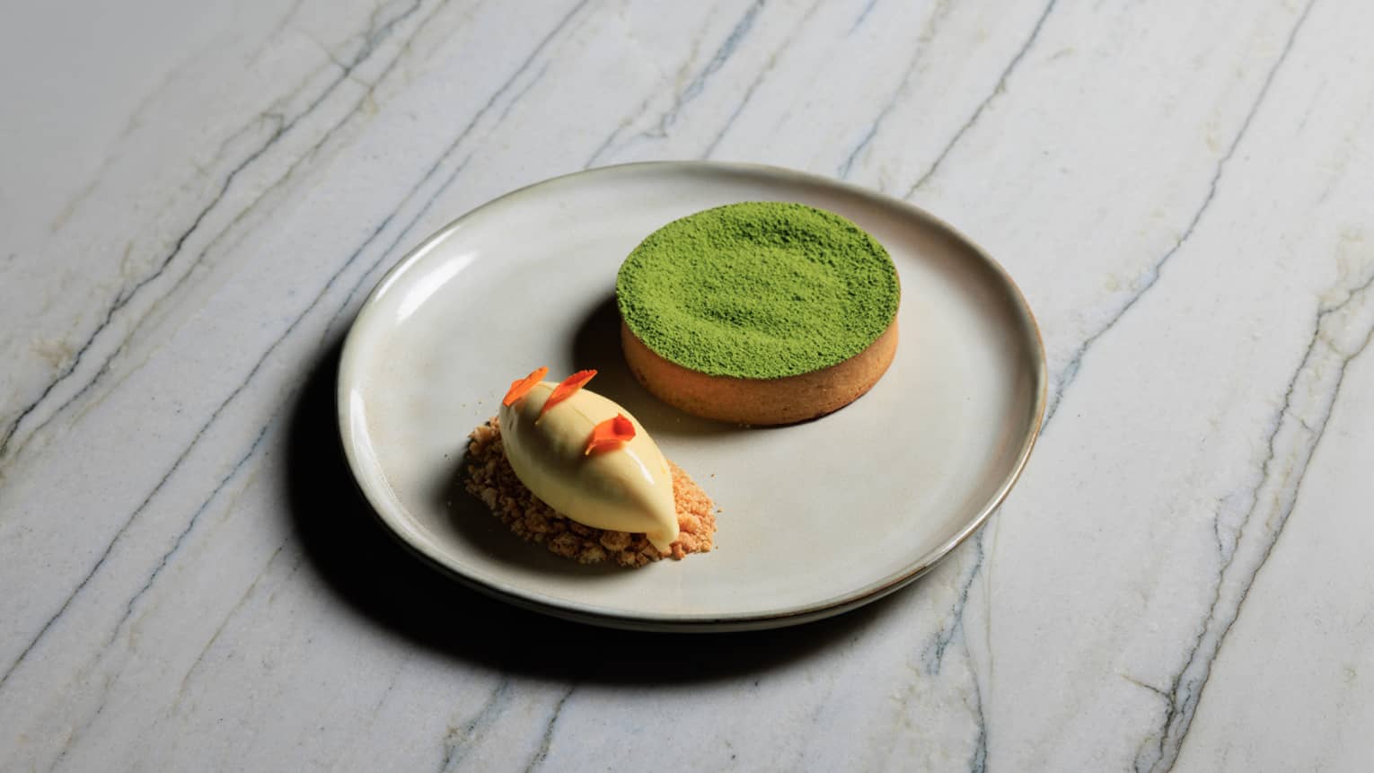 Matcha Tart with a sabl�e crust, matcha fondant and passion fruit ice cream served on a cream-coloured stoneware plate