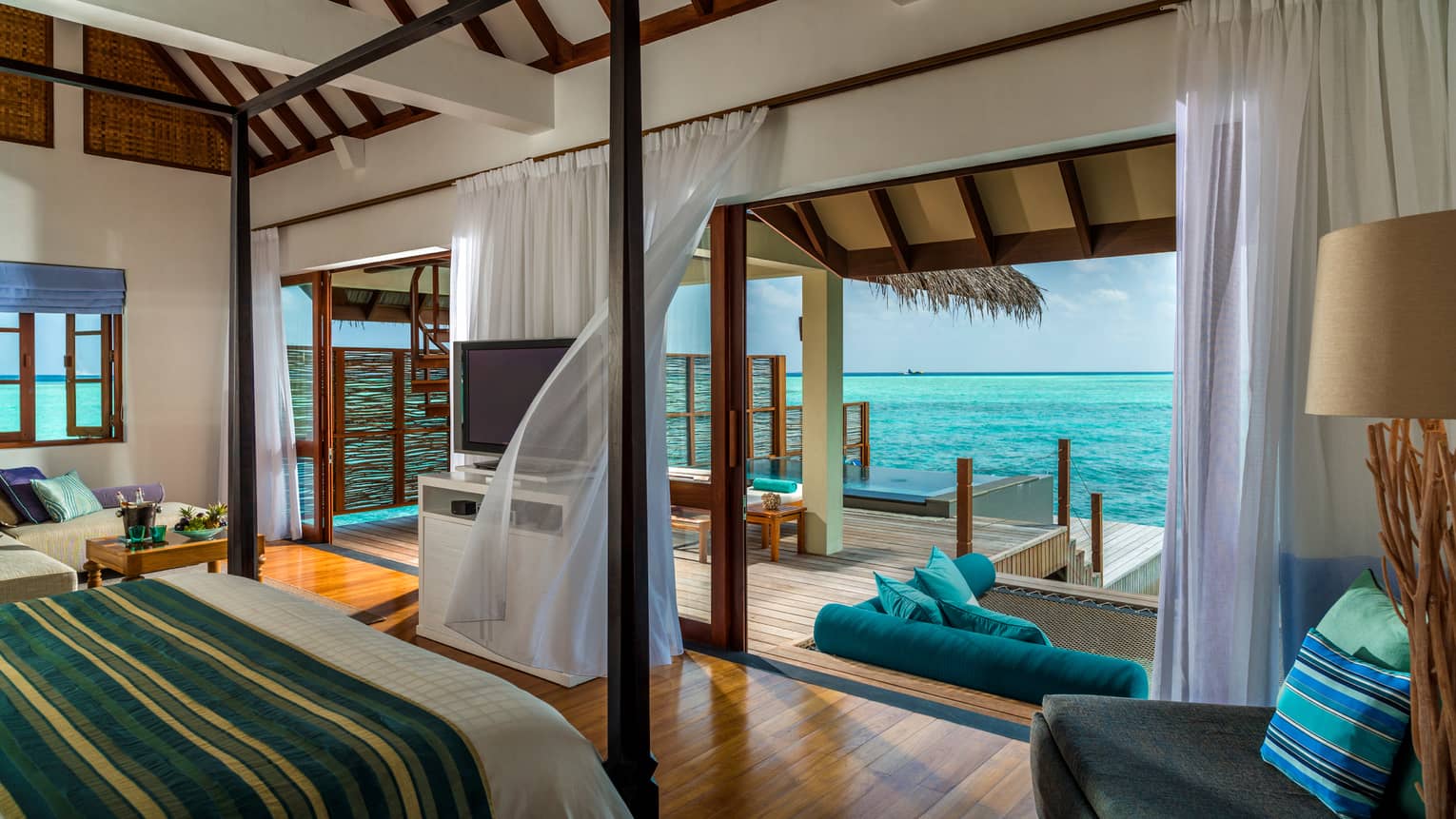 Sunrise Water Villa with Pool poster bed across from open wall to patio, sheer curtains in breeze