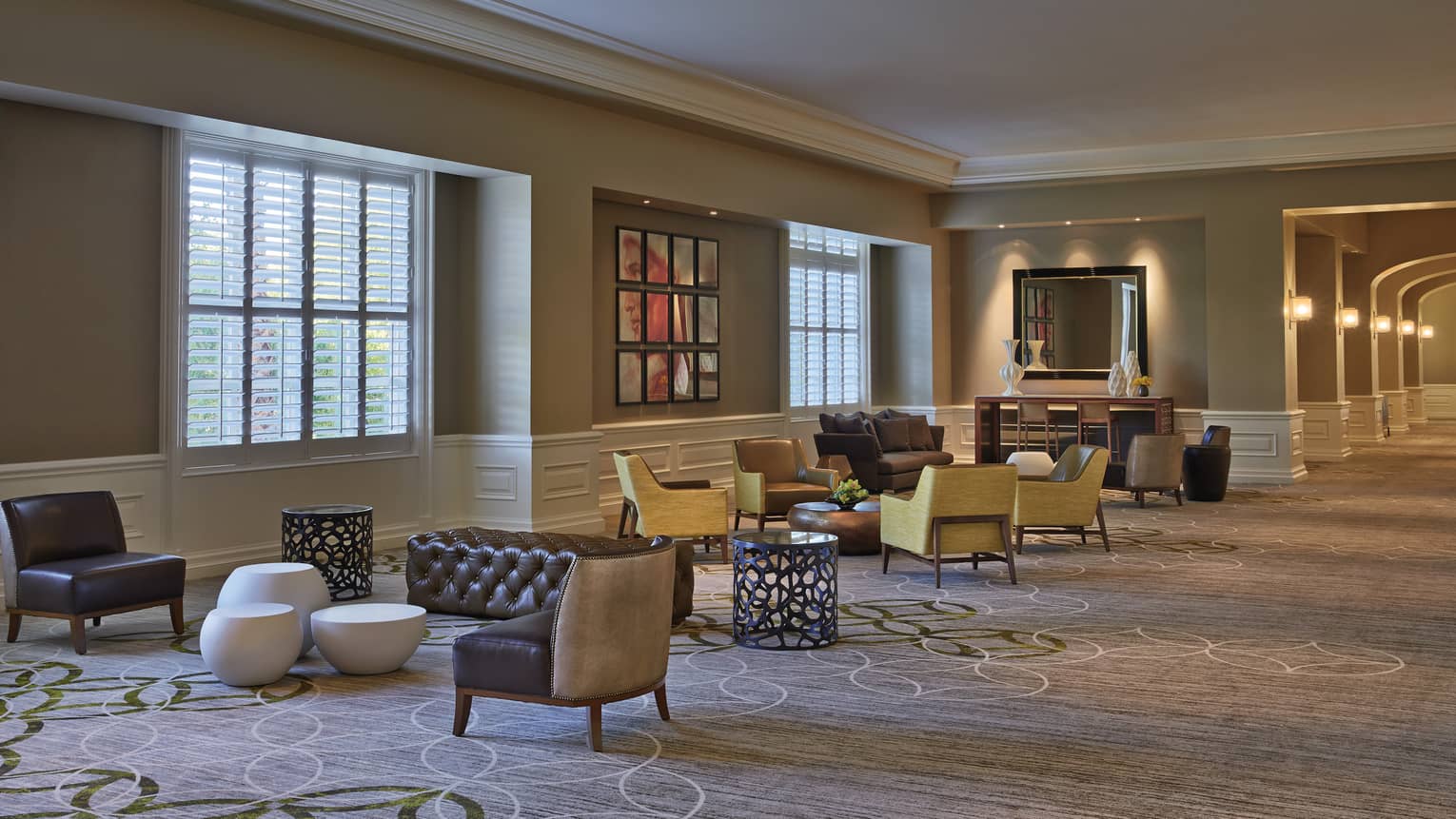 Modern armchairs, ottomans by windows in carpeted Four Seasons Ballroom Foyer