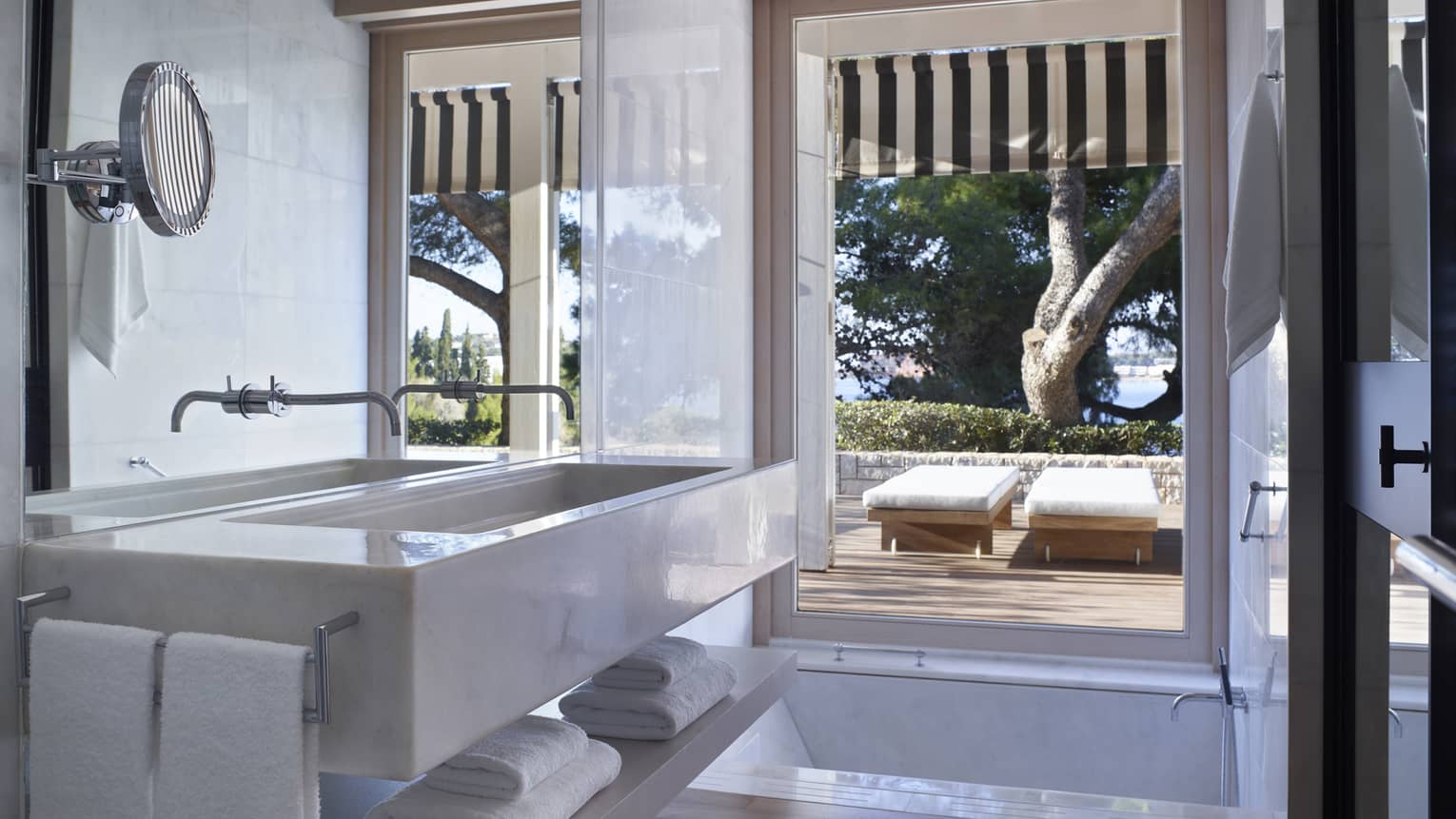 Bungalow Bathroom View with full-width marbled vanity, sink and mirror; floor-to-ceiling window overlooking terrace