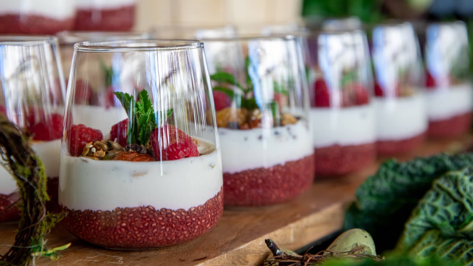 Glasses with yogurt parfait and raspberries.