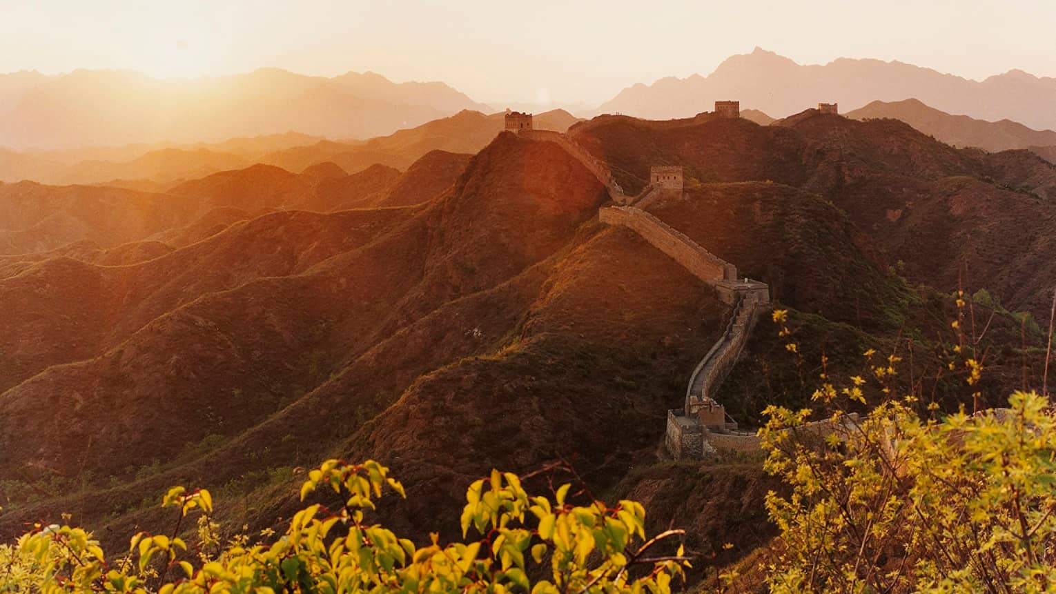 Sunset over mountain, trees with Great Wall of China along side