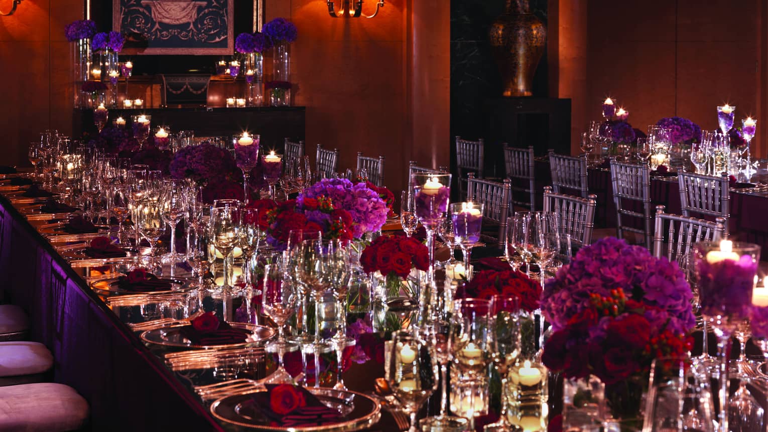 Long, elegant dining table with purple and red roses 
