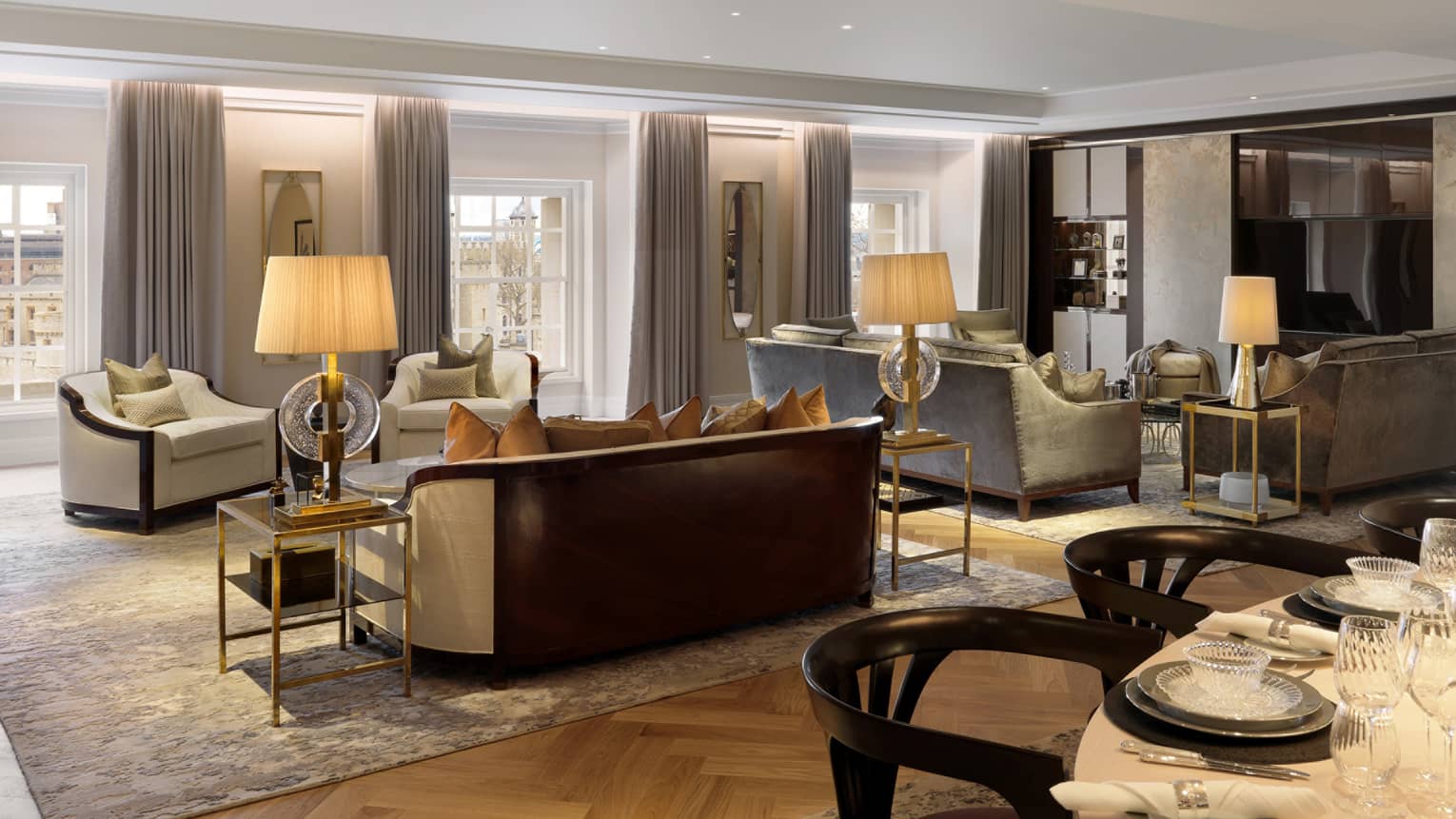 Large neutral living room with two seating vignettes flanked by lamps on side tables