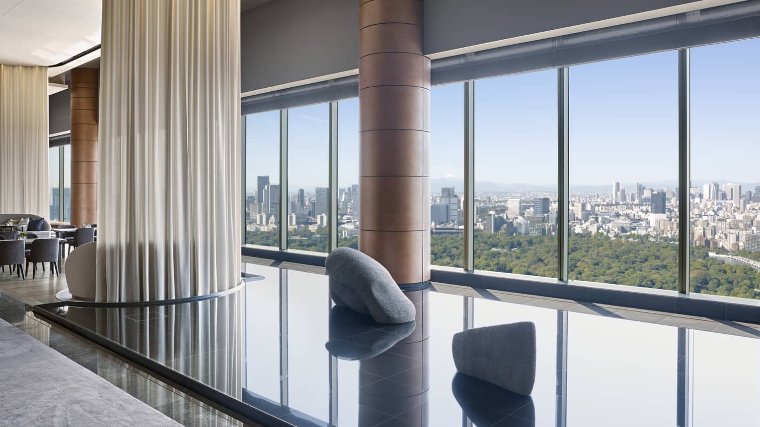 Hotel lounge featuring a calming indoor pond installation and wall of windows 
