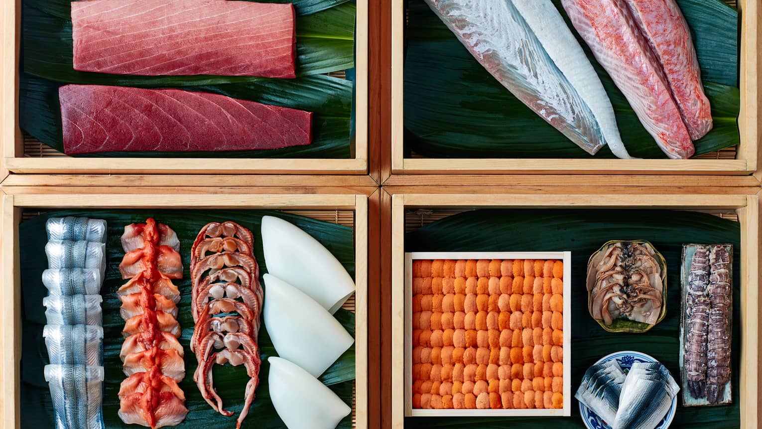 Four bamboo boxes with raw fish filets, sashimi sushi sliced fish