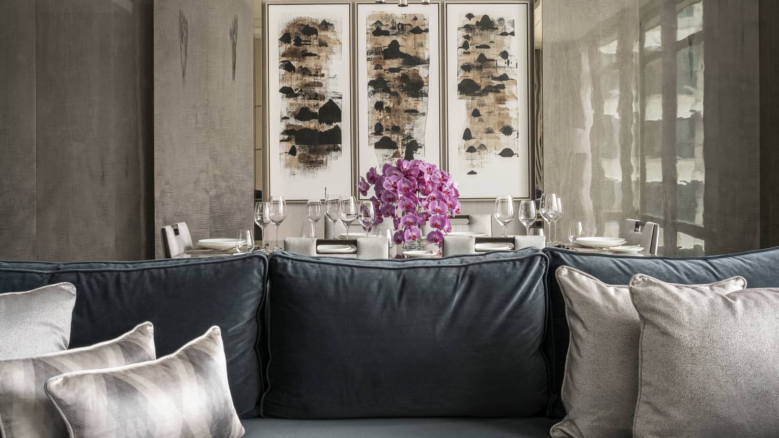 Ambassador Suite seating area with dining table in background and art on the wall