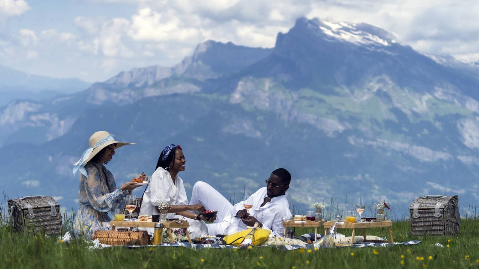 Three people enjoy a gourmet picnic in the mountains of Meg�ve, France