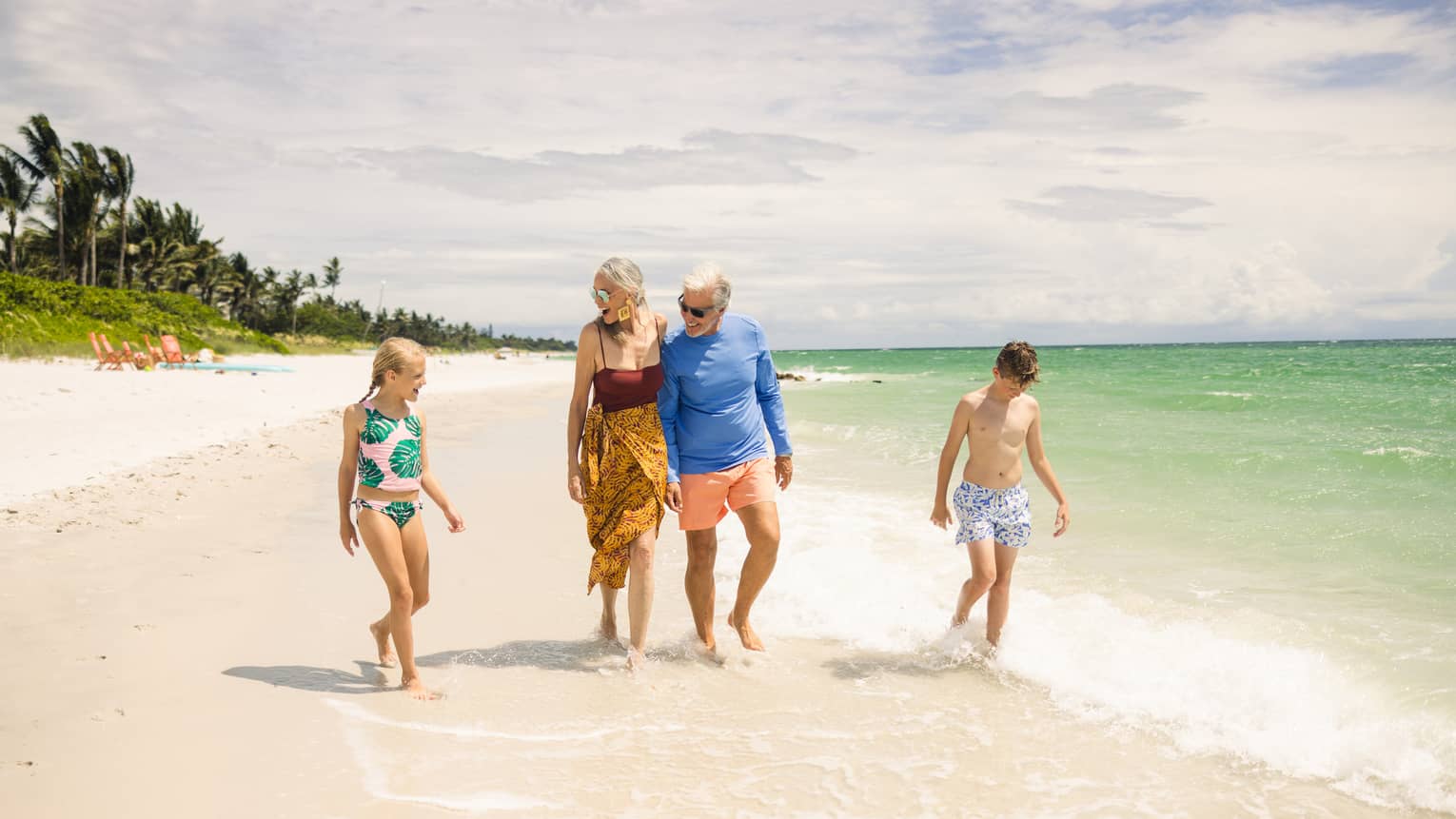 Family of four walks along a beach