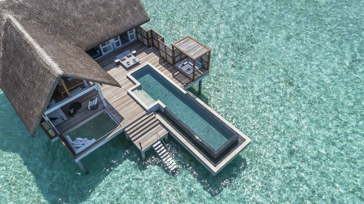Aerial view of lure island villa with private pool and deck surrounded by crystal ocean