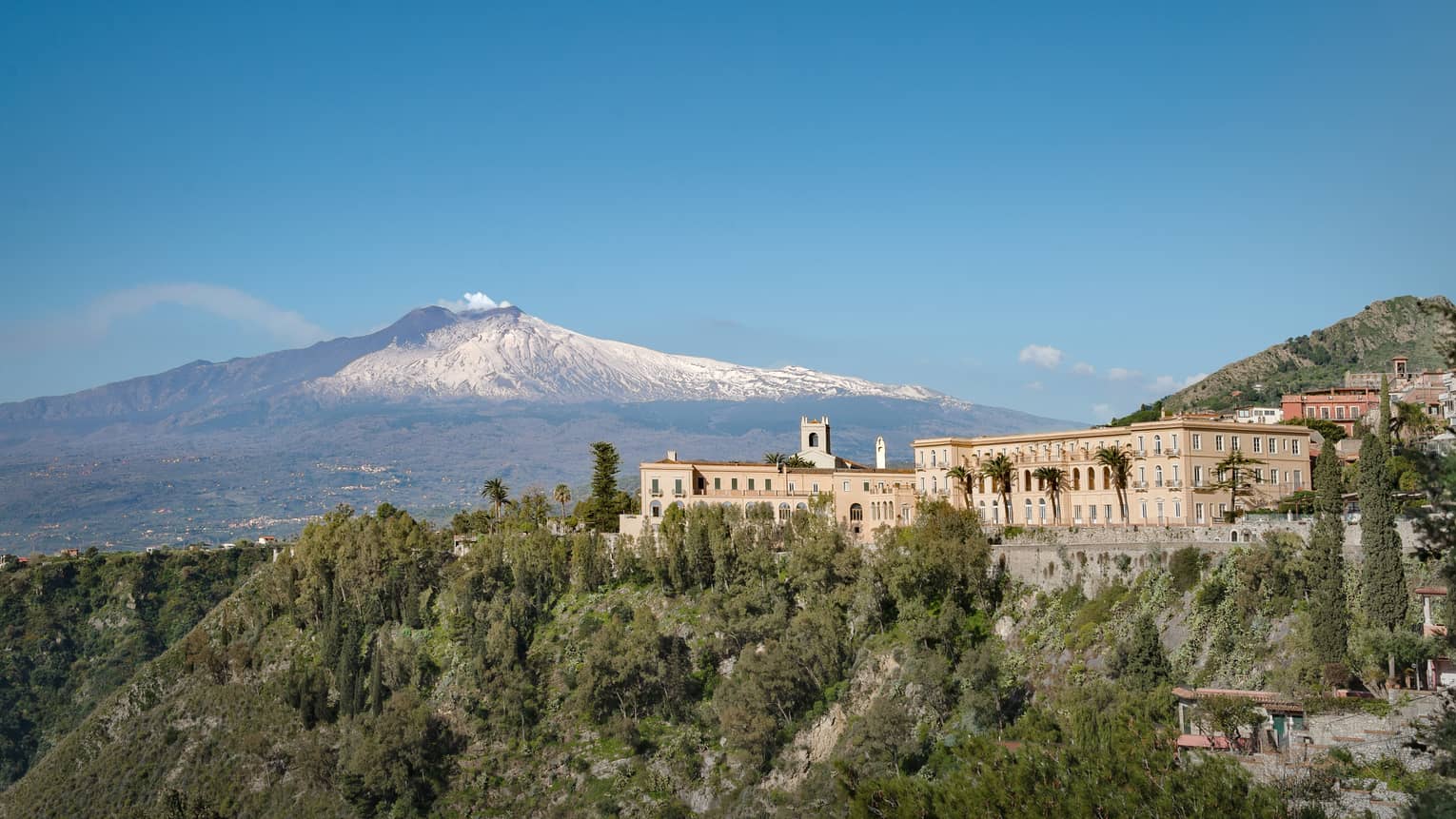 Exterior of San Domenico Palace in Taormina, Sicily, with Mount Etna in the background