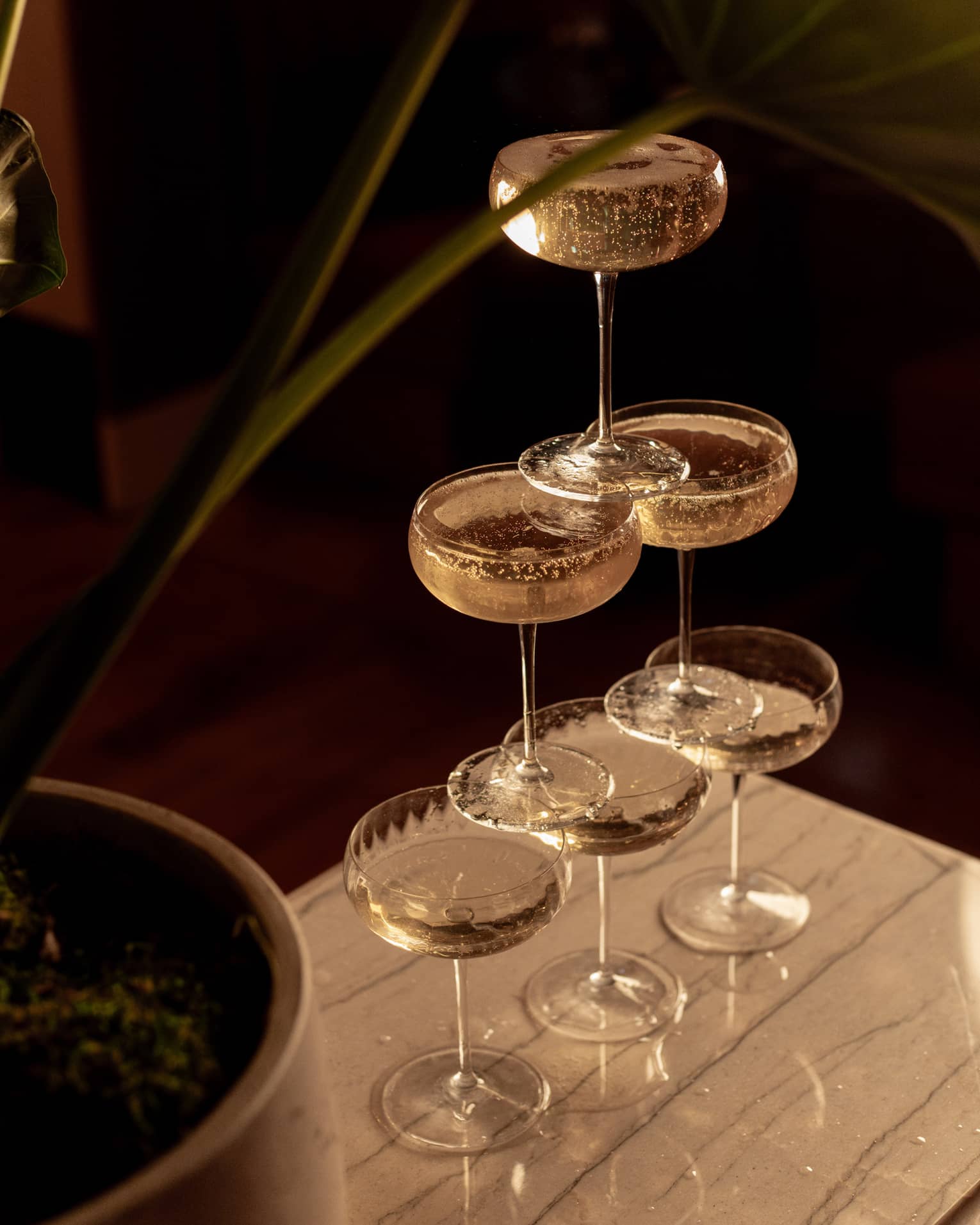 Six coupe Champagne glasses stacked in a pyramid