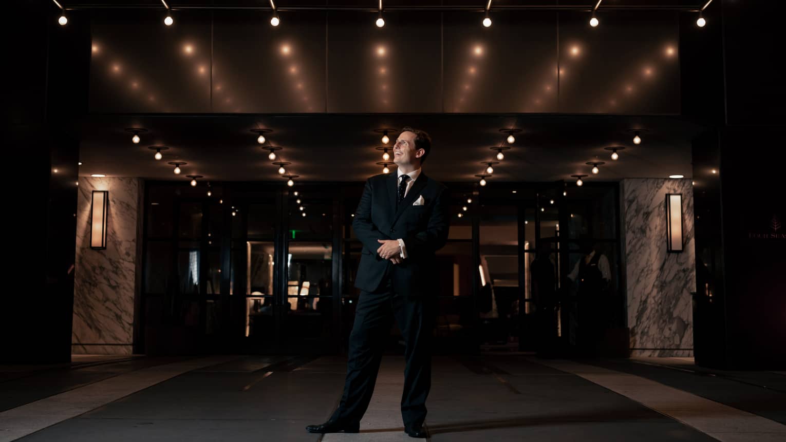 A man in a suit in a dimly lit area.