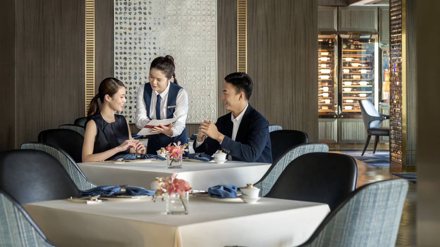 Waitress shows menu to couple dining at Vista 38