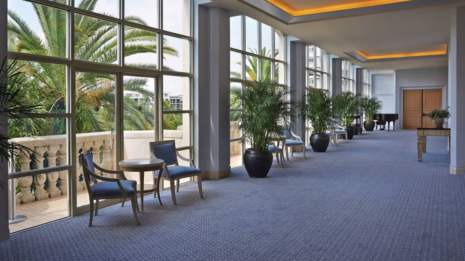 Royal Poinciana ballroom foyer with floor-to-ceiling loft windows, orange lights along ceiling