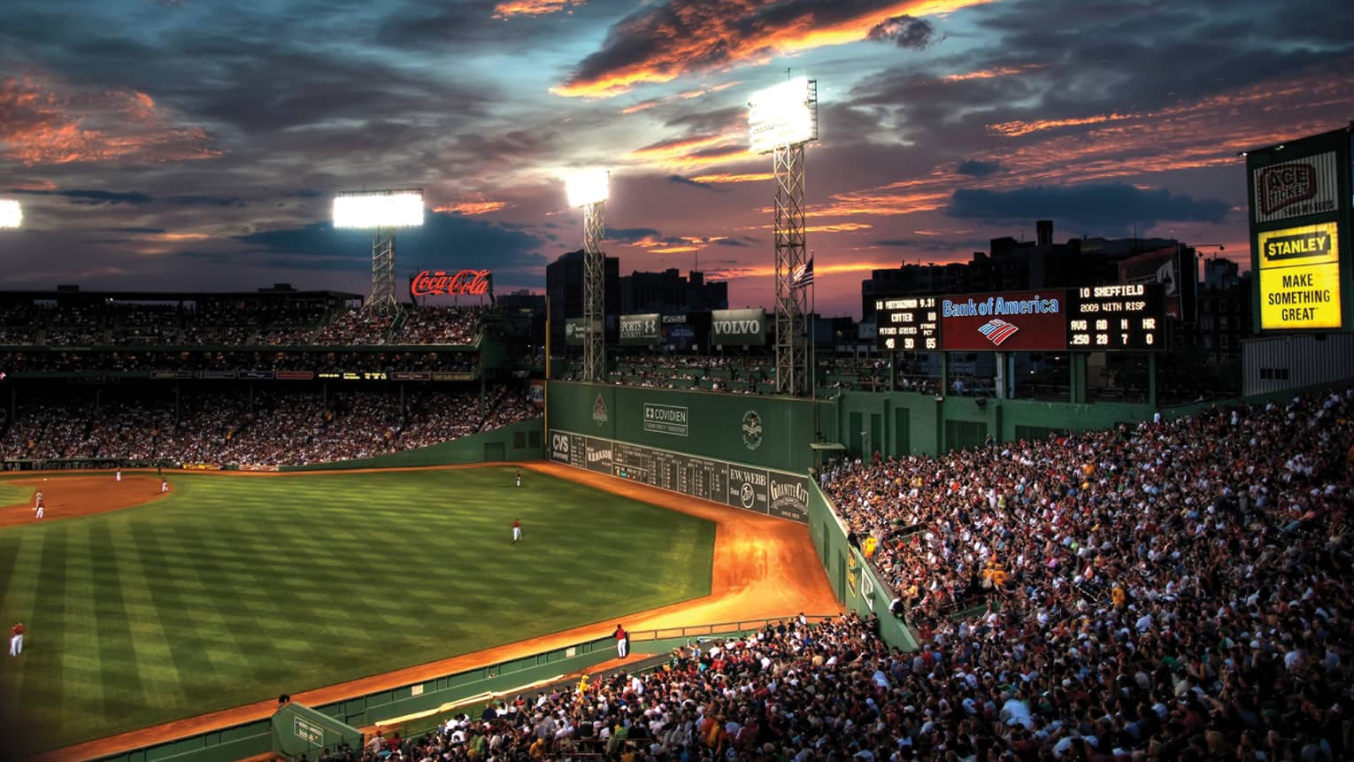 the sun sets over fenway park in boston